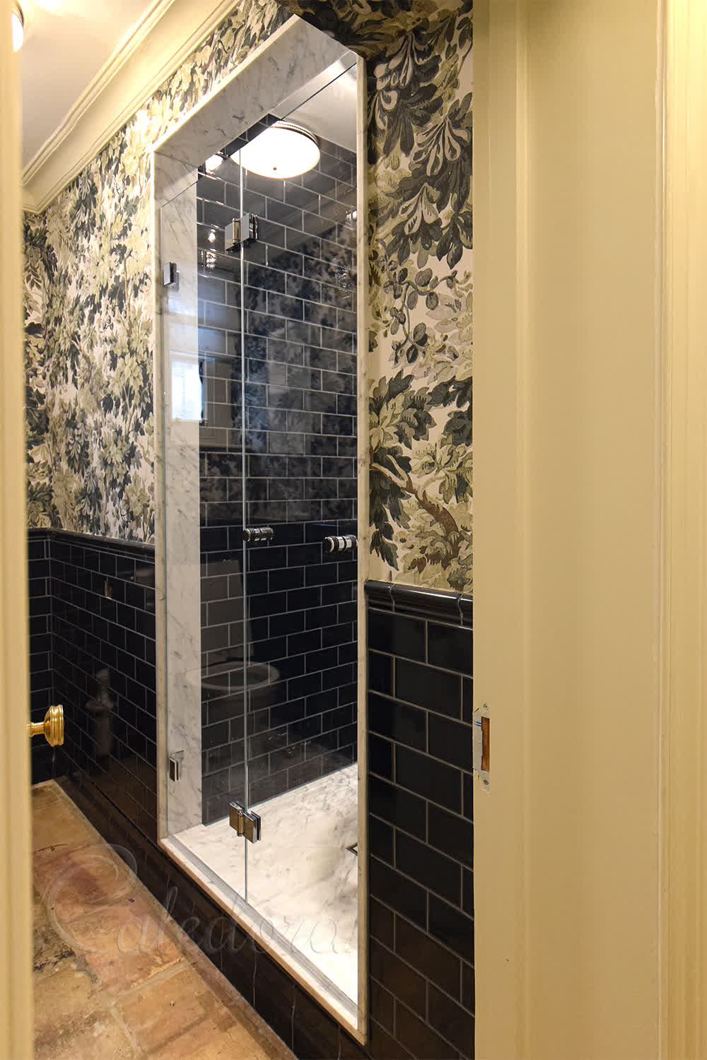 Frameless bifold shower door with chrome hinges in London bathroom