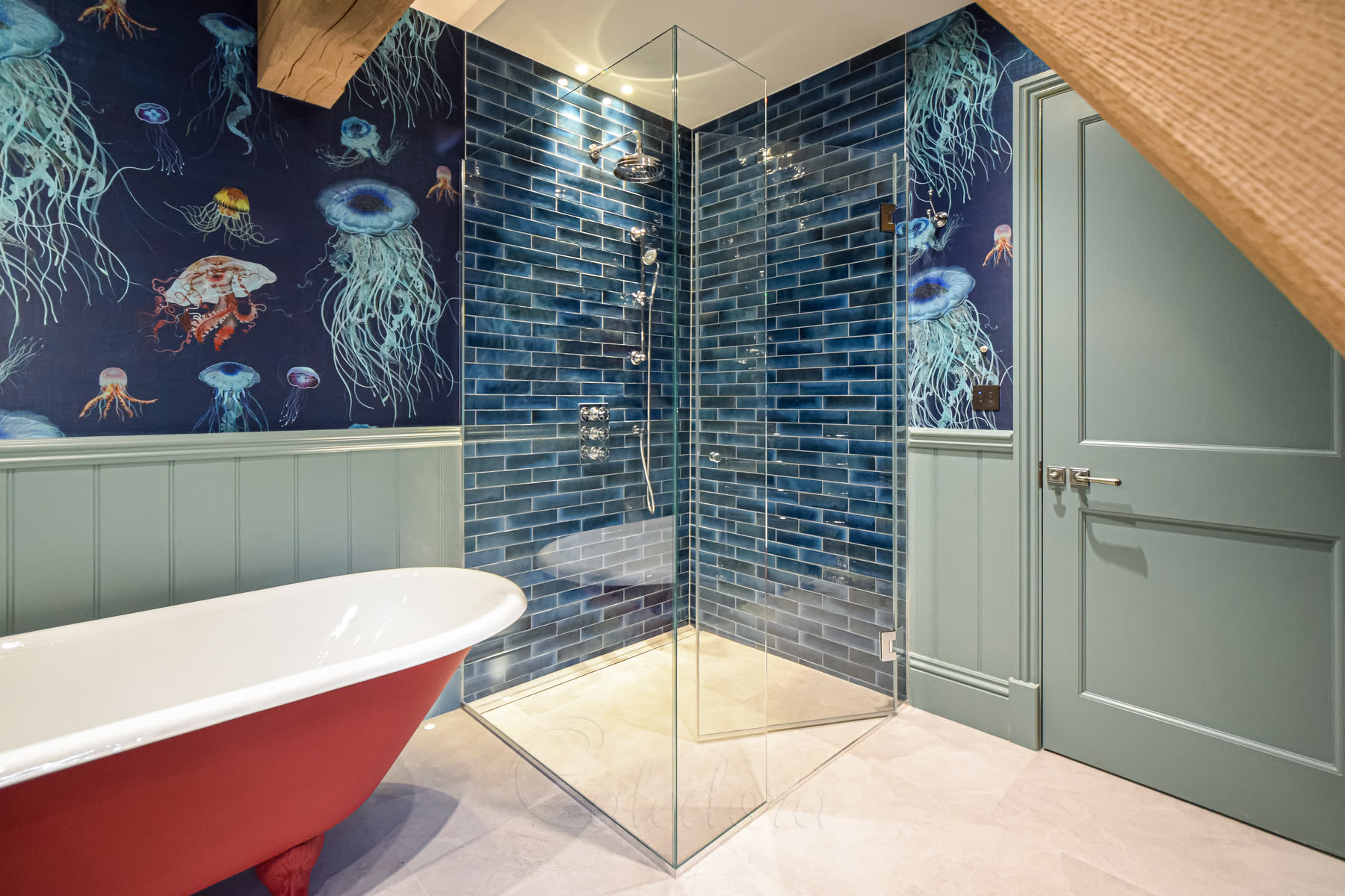Wide view of frameless shower enclosure corner installation with red bathtub and wooden ceiling beams