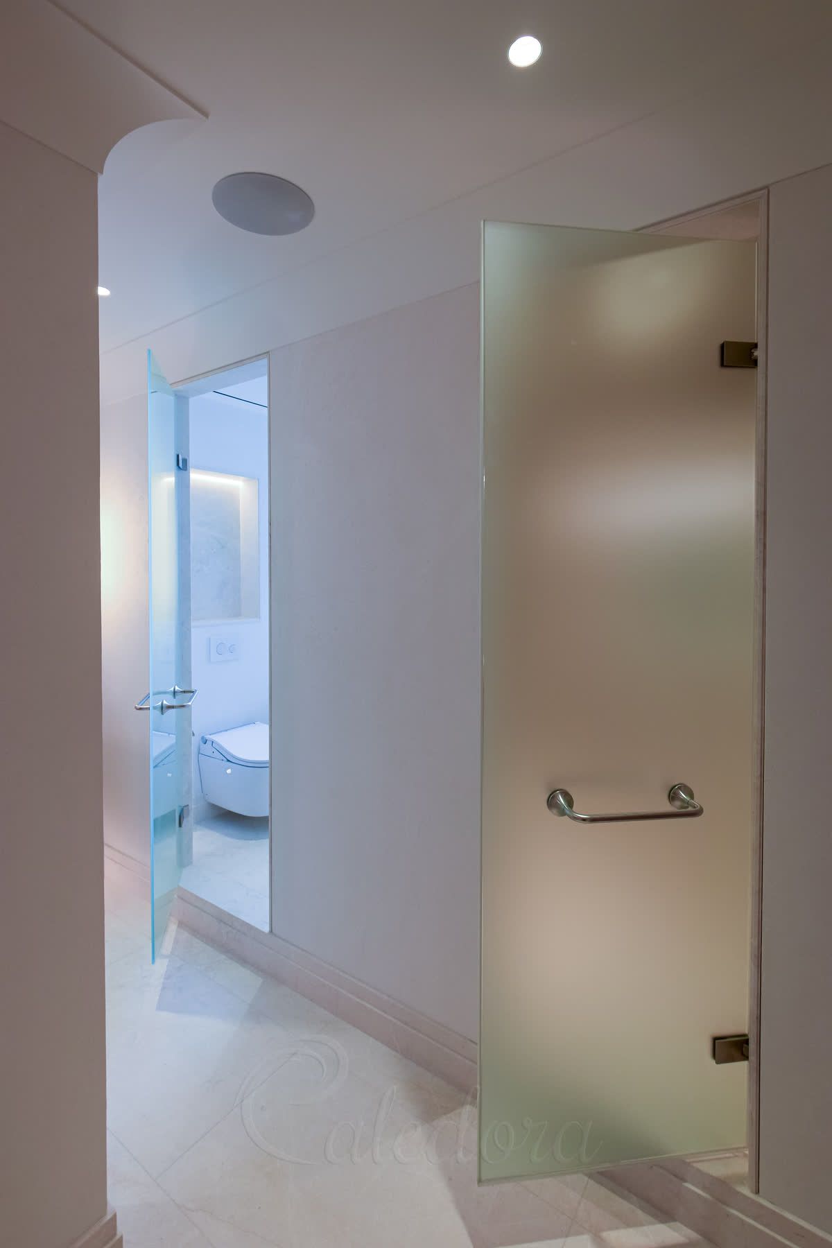 Side view of frameless frosted glass shower door showing thin profile and precision installation