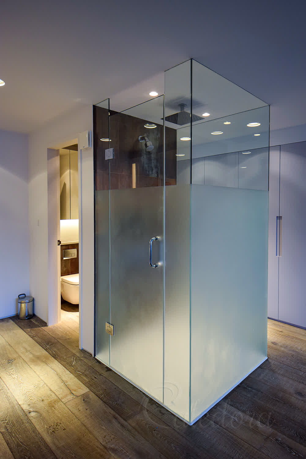 Frosted glass shower enclosure with sandblasted privacy section in London bathroom