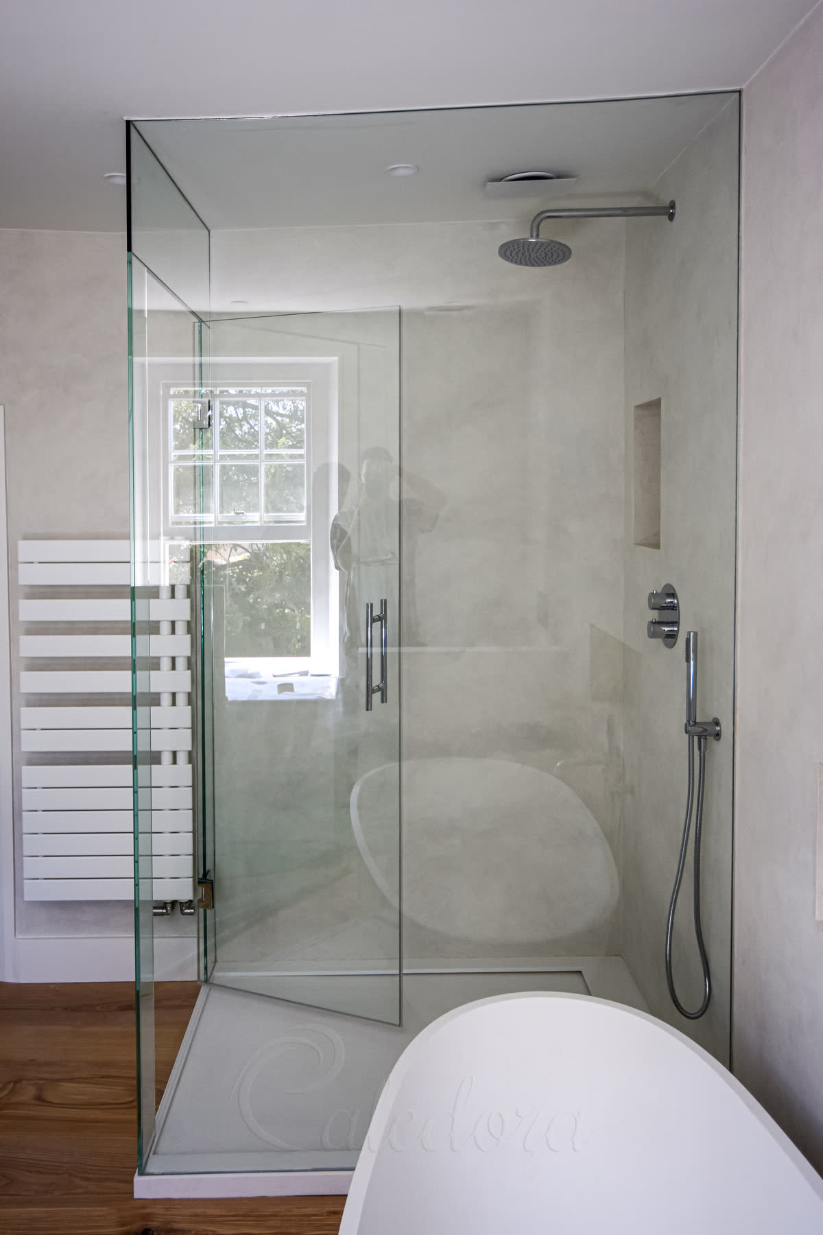 Full height frameless shower enclosure showing curved ceiling detail and glass-to-glass hinges