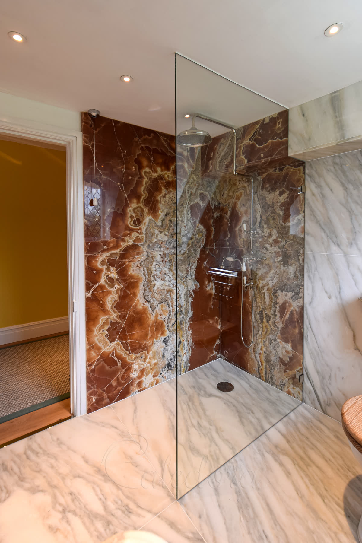 Full-height bespoke walk-in shower screen shaped to ceiling with chrome wall fixings