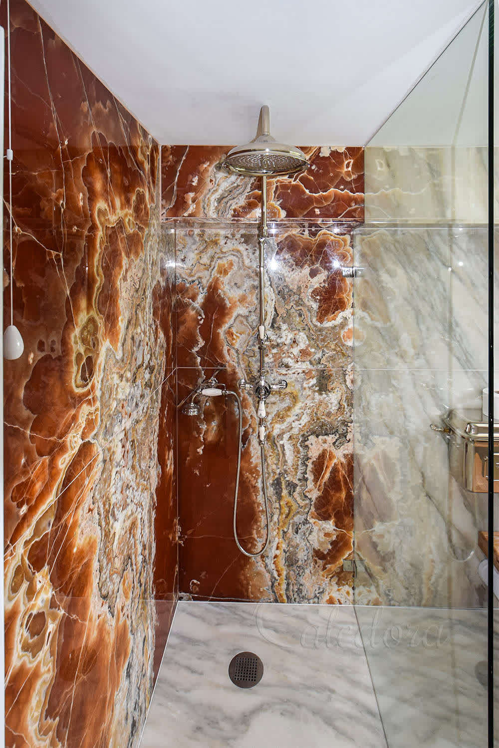 Walk-in full-height shower glass custom cut to ceiling, shaped and installed as a single unit