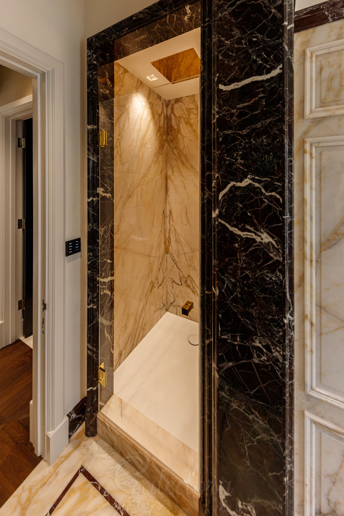 Detailed view of gold hinges and square doorknob on ultra clear glass door with minimalistic seals in London installation