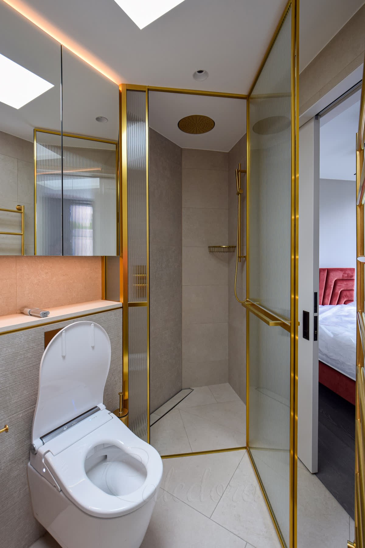 Fully open gold shower door revealing bespoke towel rail and discrete 2mm seals with matching threshold