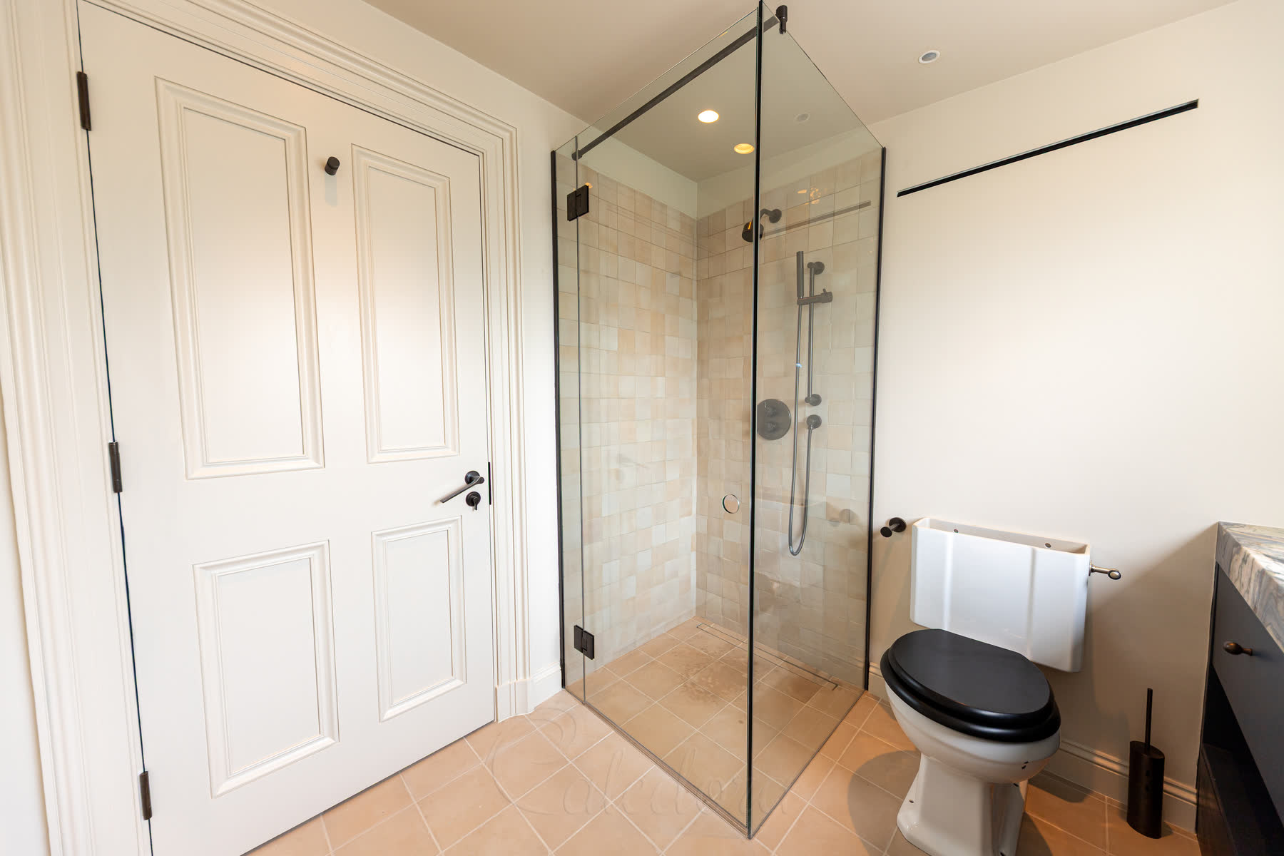 Gunmetal shower enclosure corner installation with glass-to-glass hinged door and small return panel