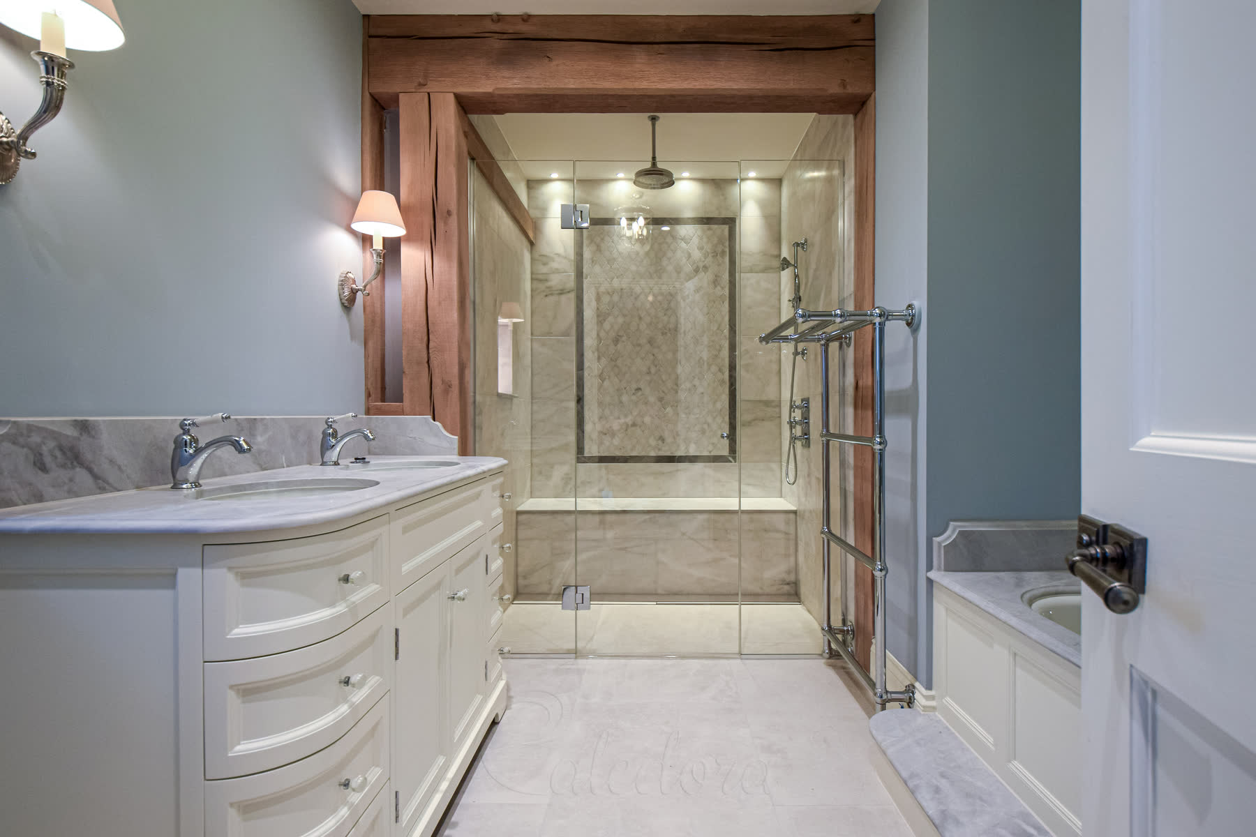 Overall view of modern bathroom with frameless shower enclosure, vanity unit, and towel radiator
