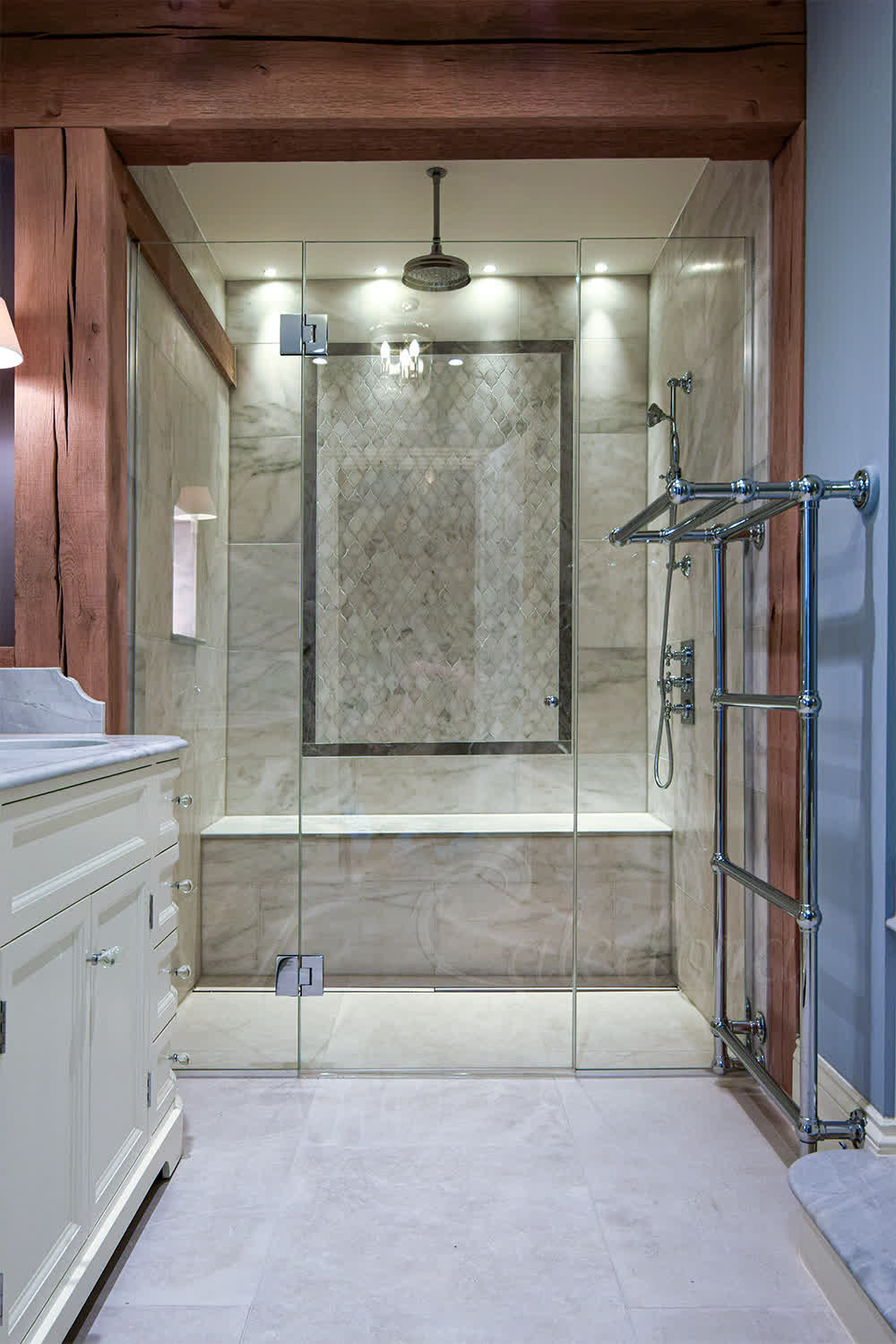 Frameless hinged shower door with chrome hinges shown closed in tiled Beaconsfield bathroom