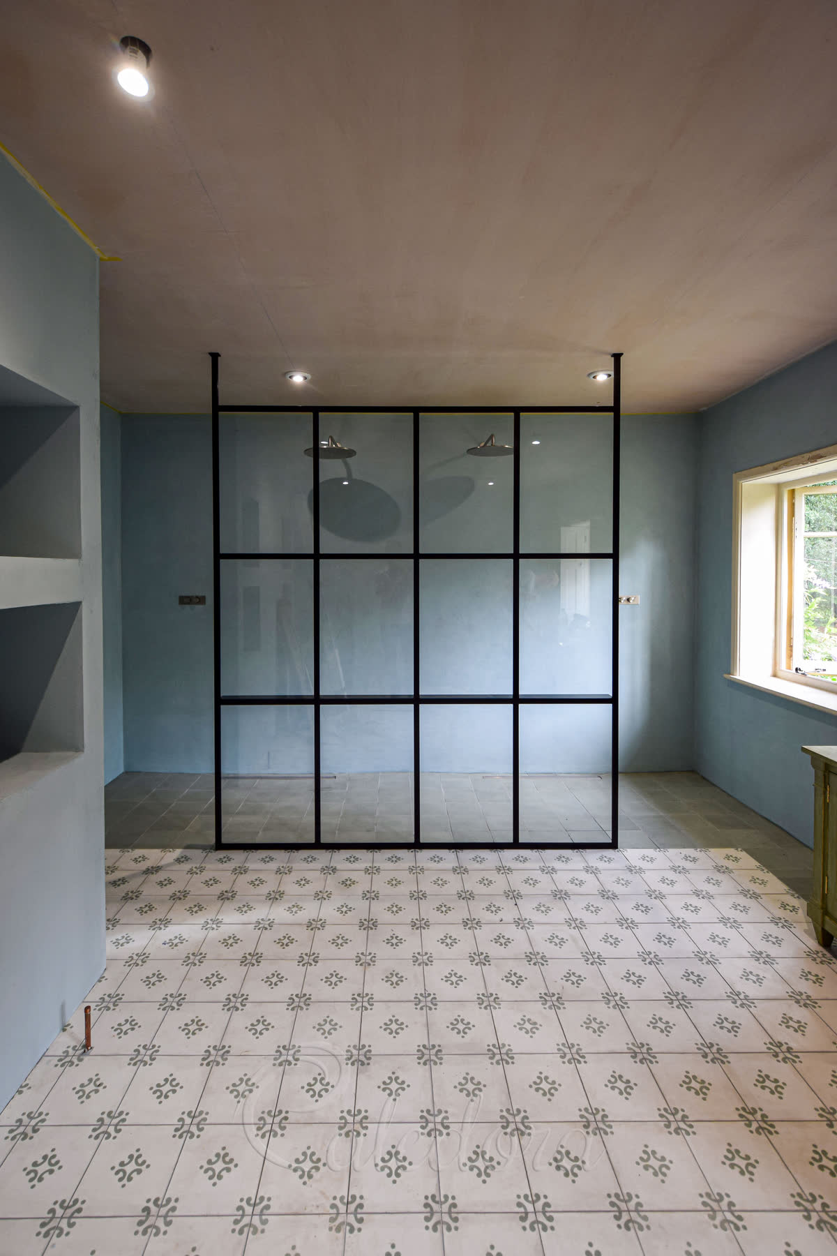 Black grid floor-to-ceiling walk-in shower screen dividing a Lewes bathroom into shower and dressing zones
