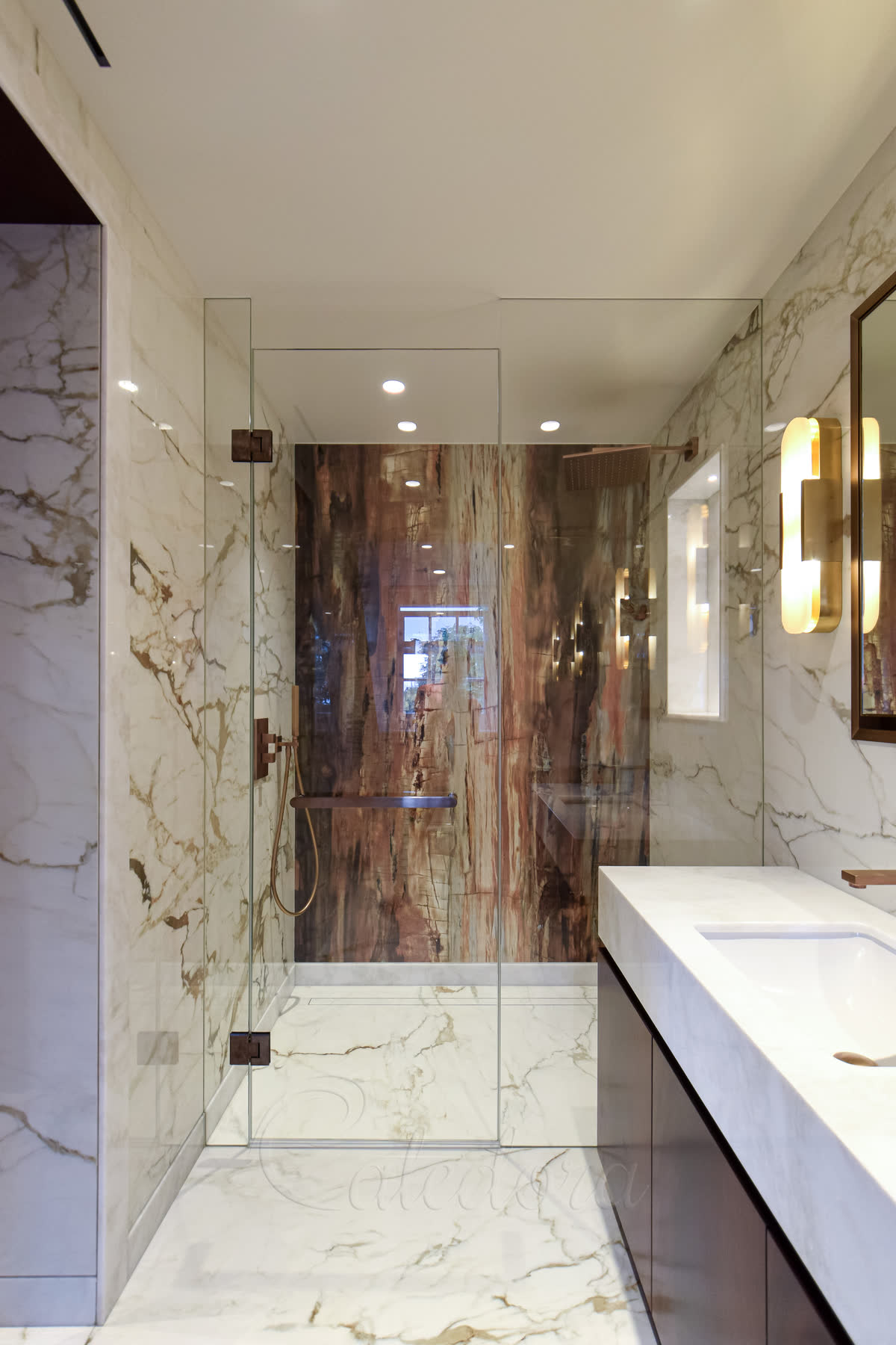 Wall-to-wall frameless shower door with antique copper fittings