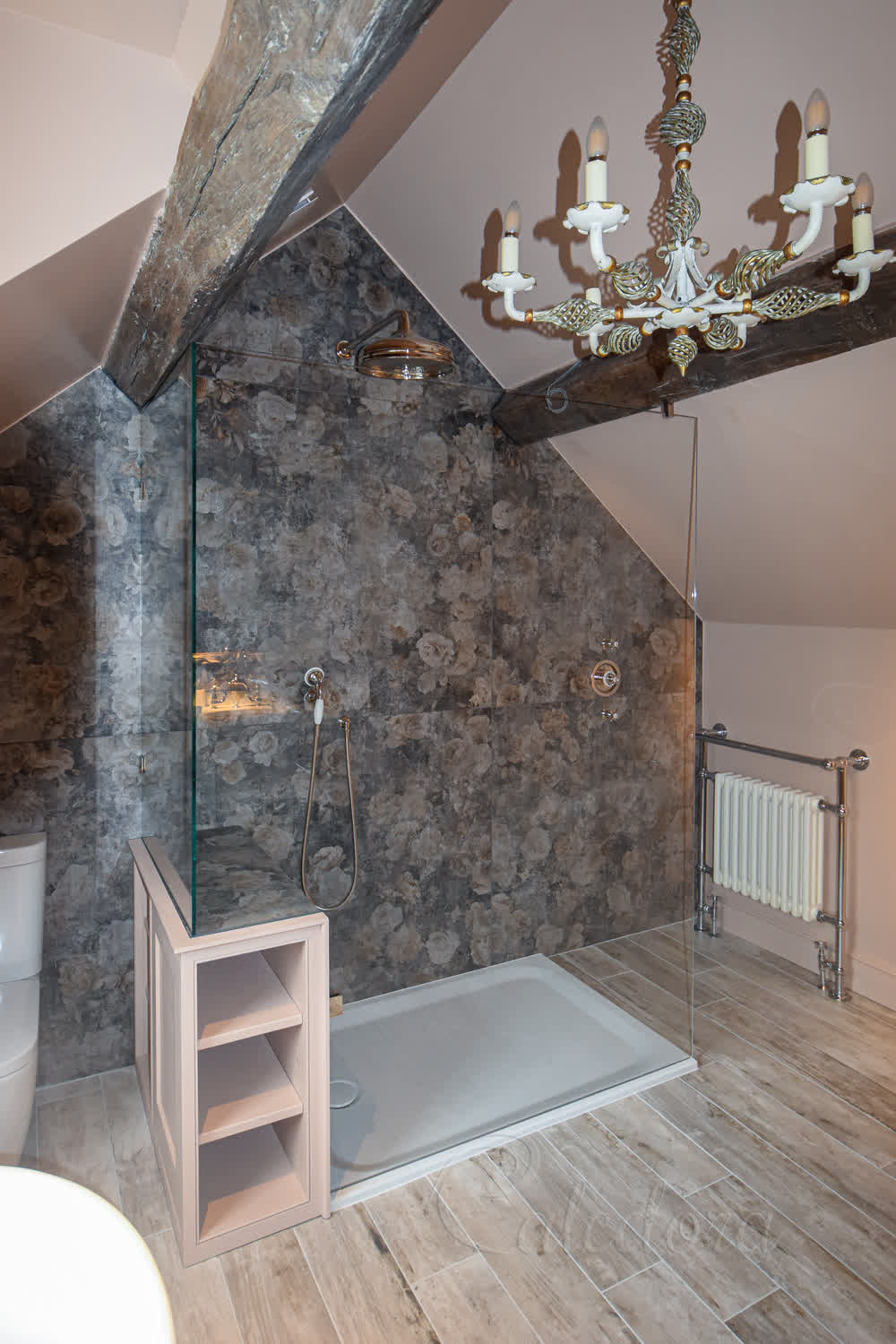 Frameless L-shaped shower screen with nickel fittings in a loft bathroom