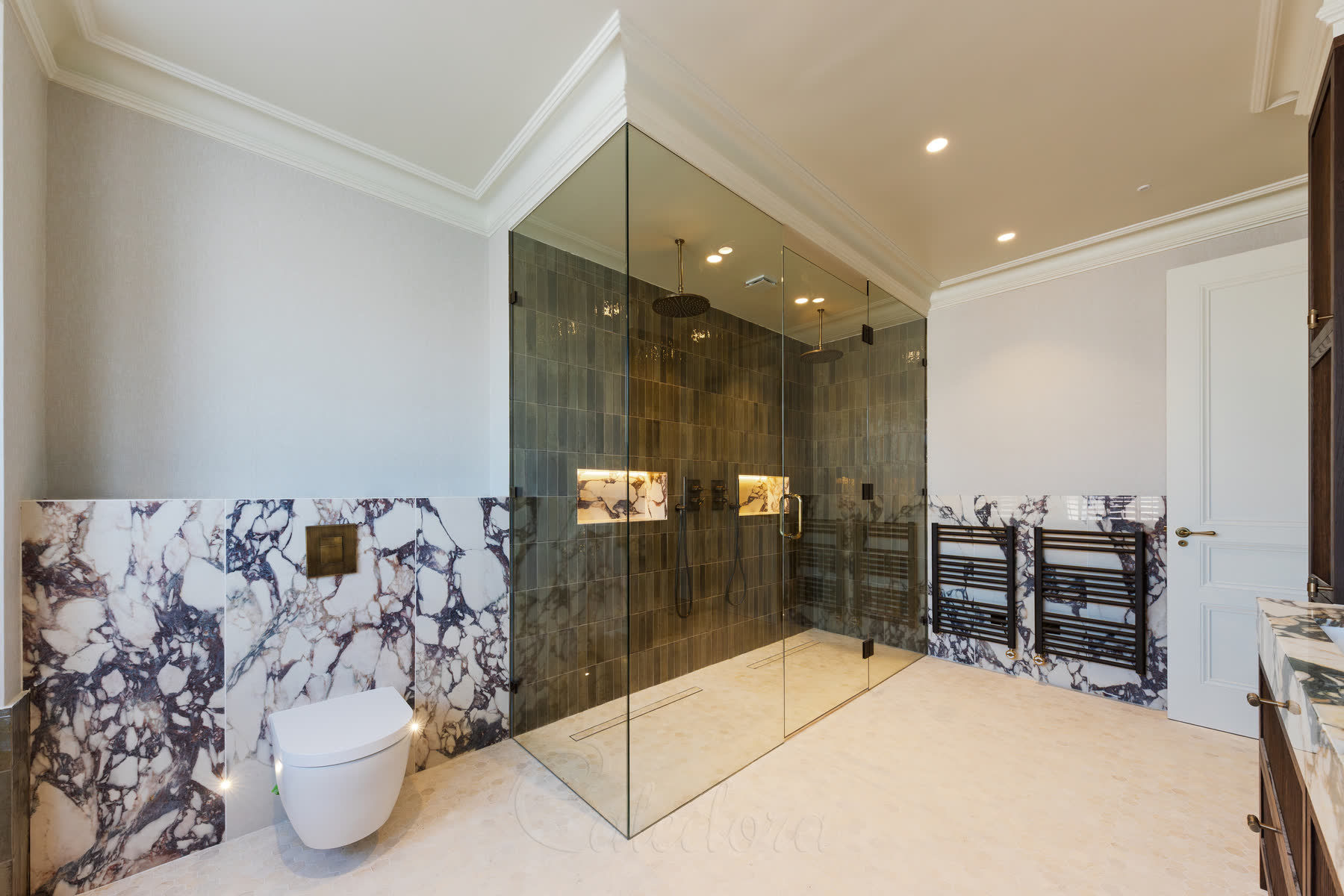 Double shower enclosure with antique brass hardware and marble bathroom finishes