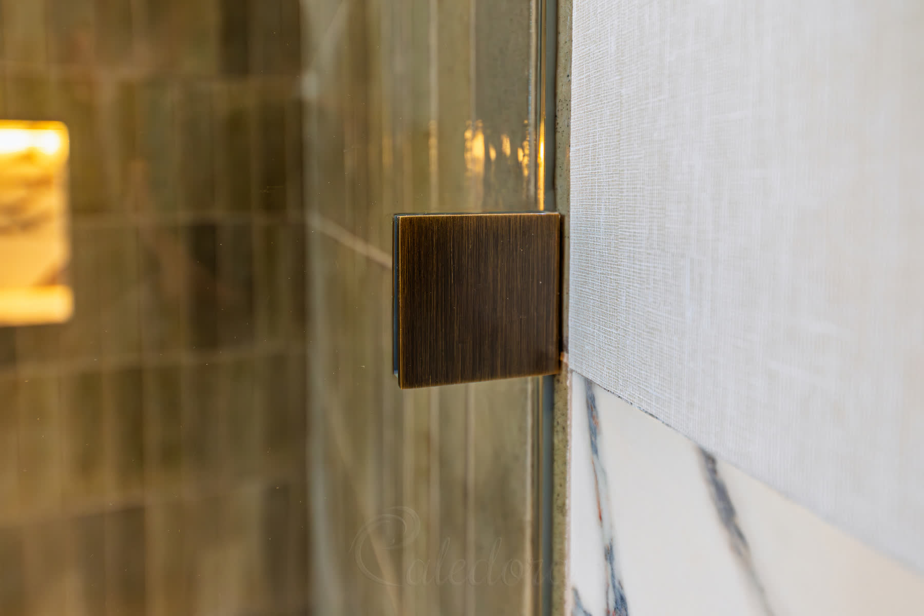 Wall bracket detail showing 50x50mm square brass fixtures aligned with hinges