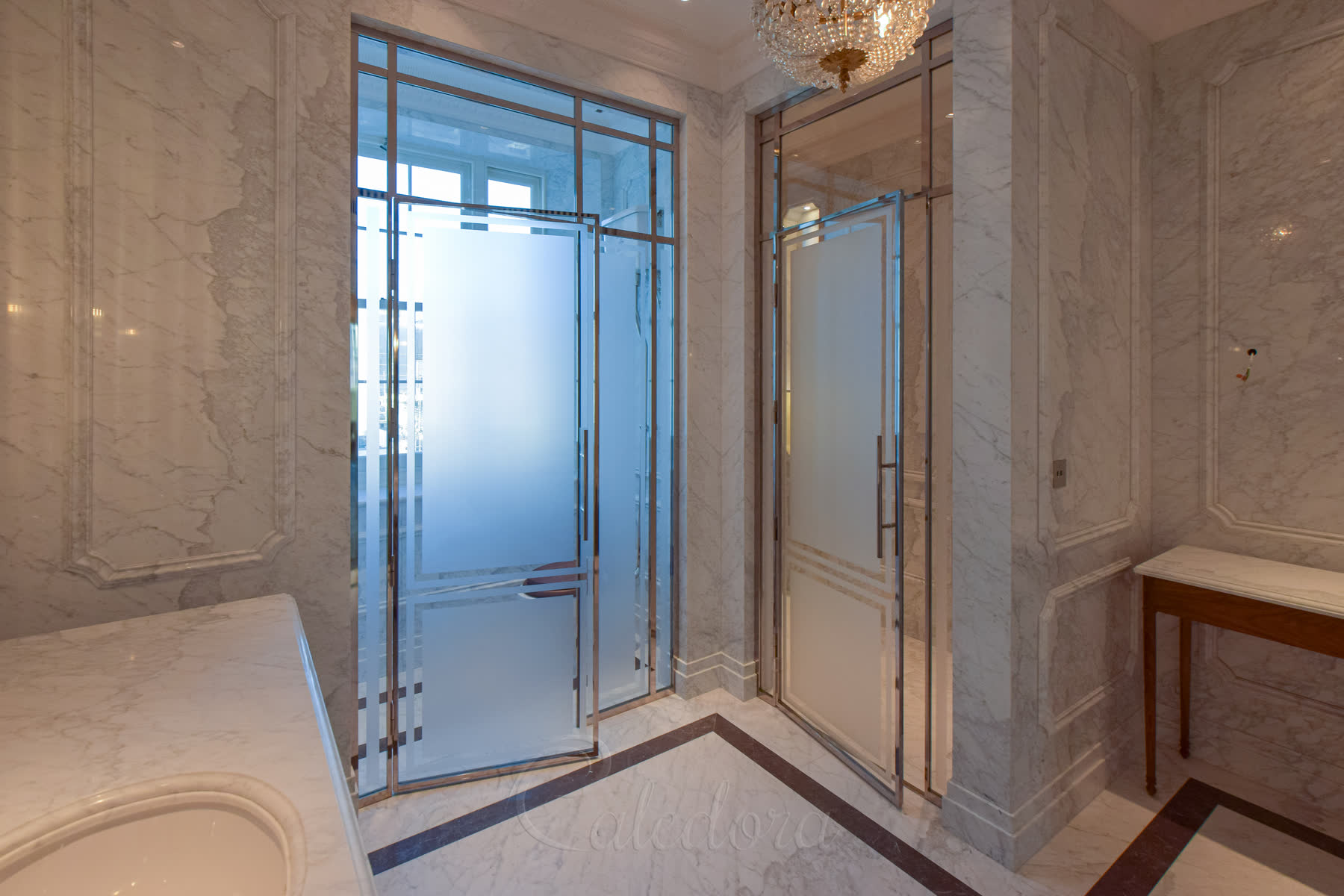 Full bathroom view showing nickel shower door alongside matching WC partition in luxury marble setting
