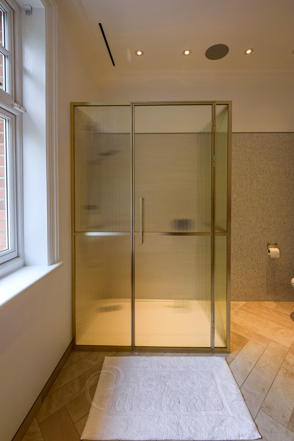 Corner bright gold shower enclosure with reeded glass panels showing full front view