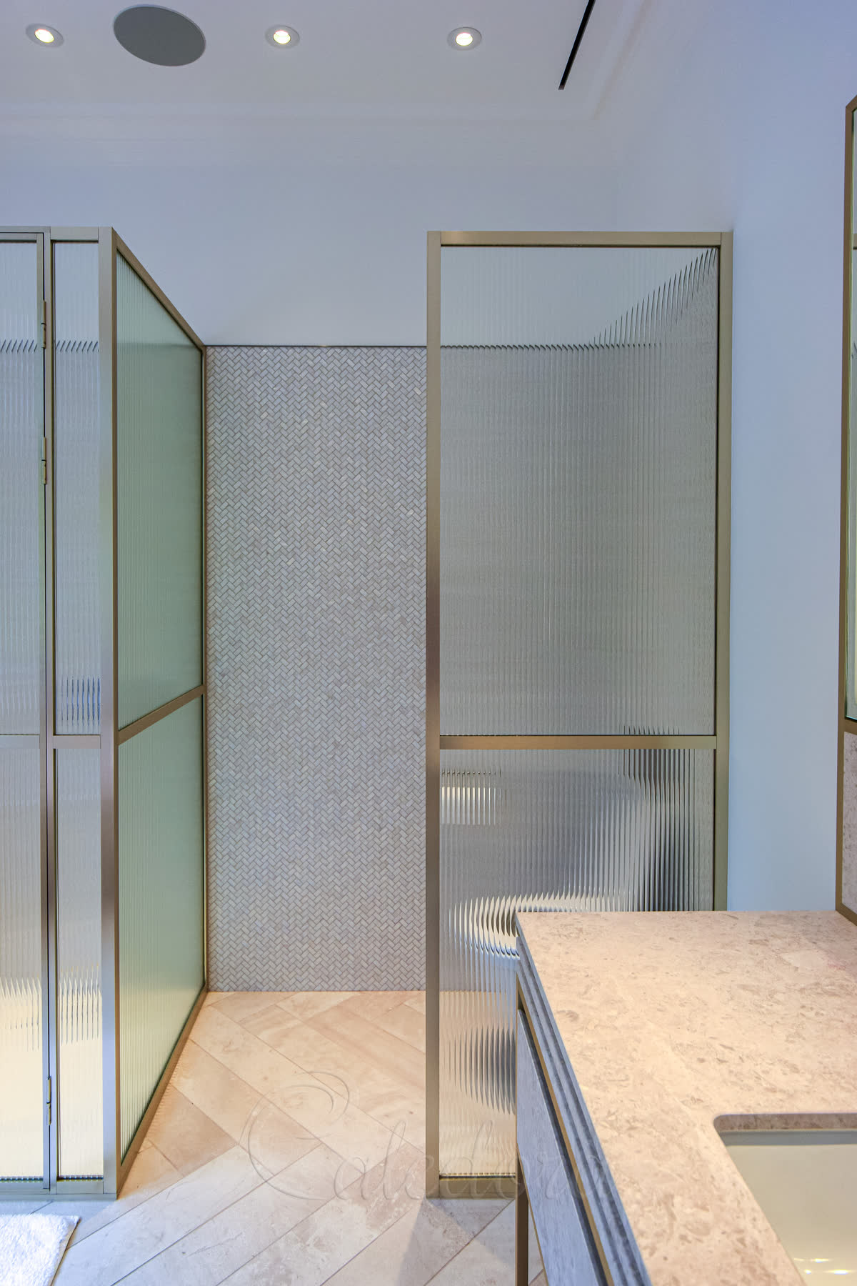 Matching bright gold framed panel with reeded glass for toilet area integration
