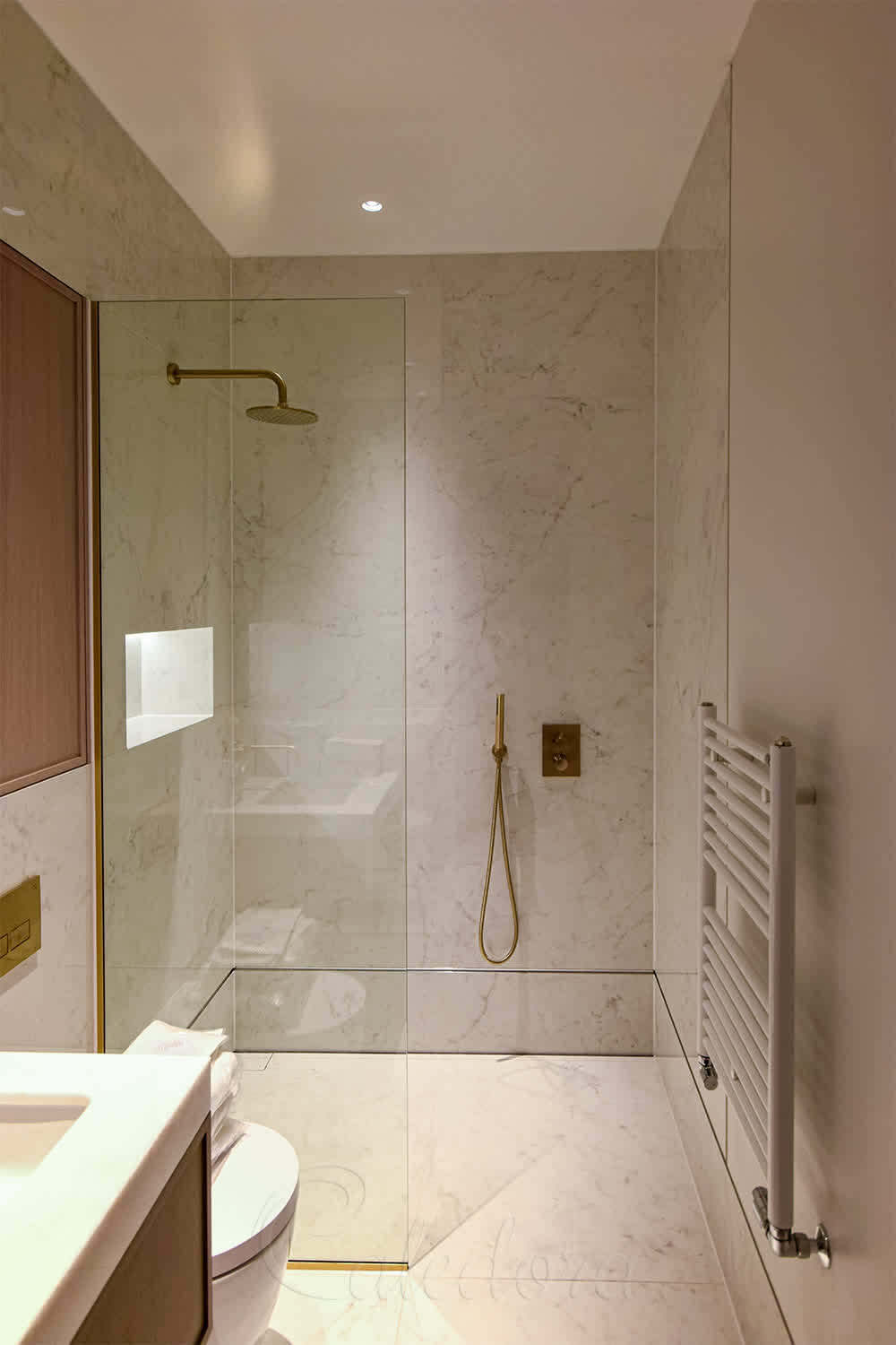 Short shower screen with brass fixtures showing wide entrance opening