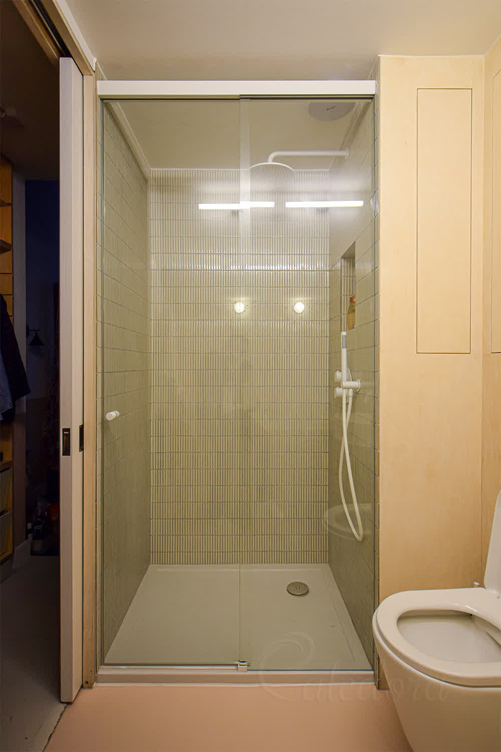 White sliding shower door with clear glass, powder-coated track and minimalistic detailing installed in London