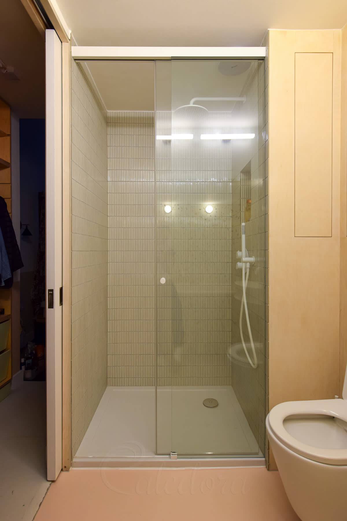 Frameless white sliding shower door with clear glass and minimal seals