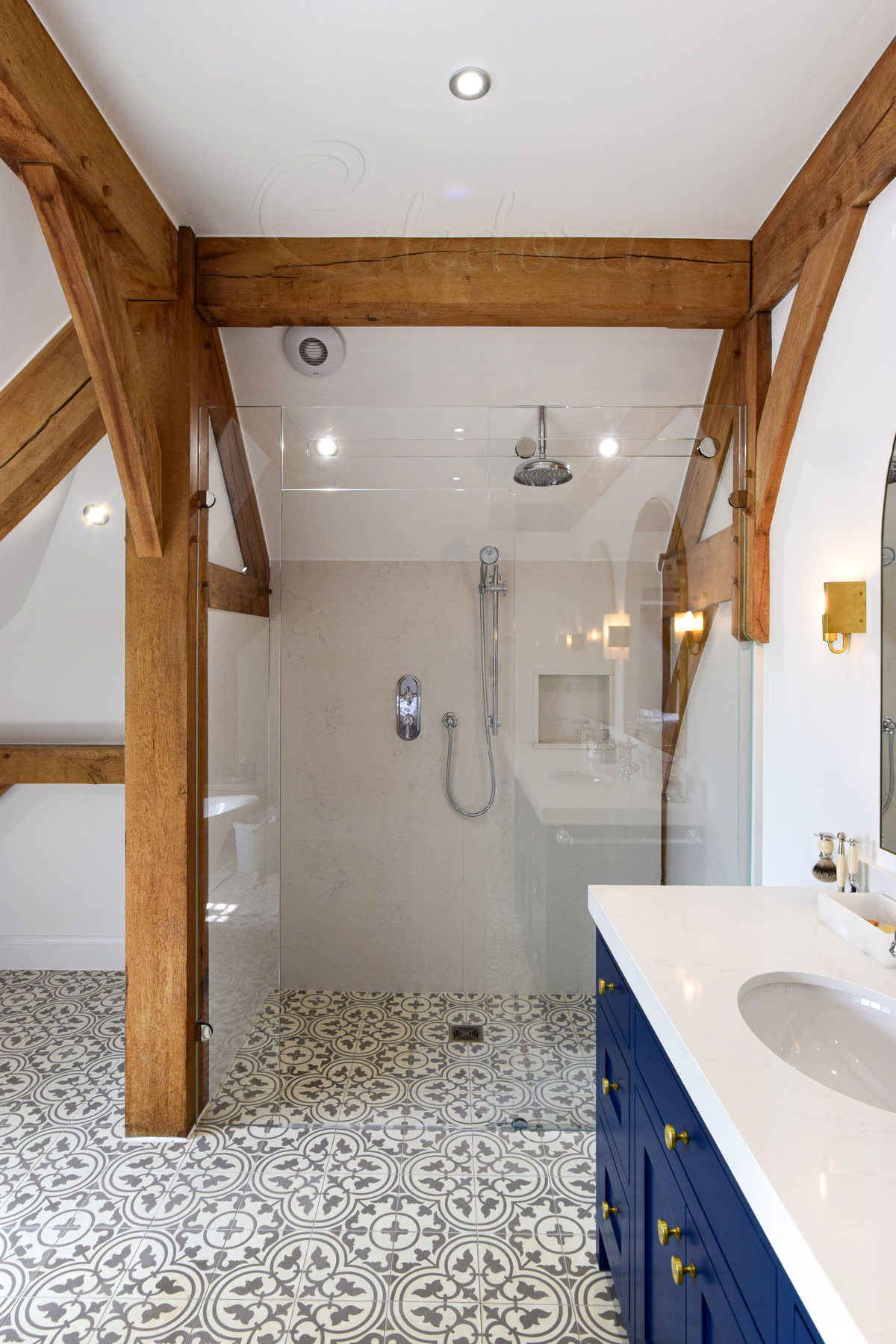 Frameless sliding shower screen with trackless system and ultra clear glass in modern bathroom with natural stone walls