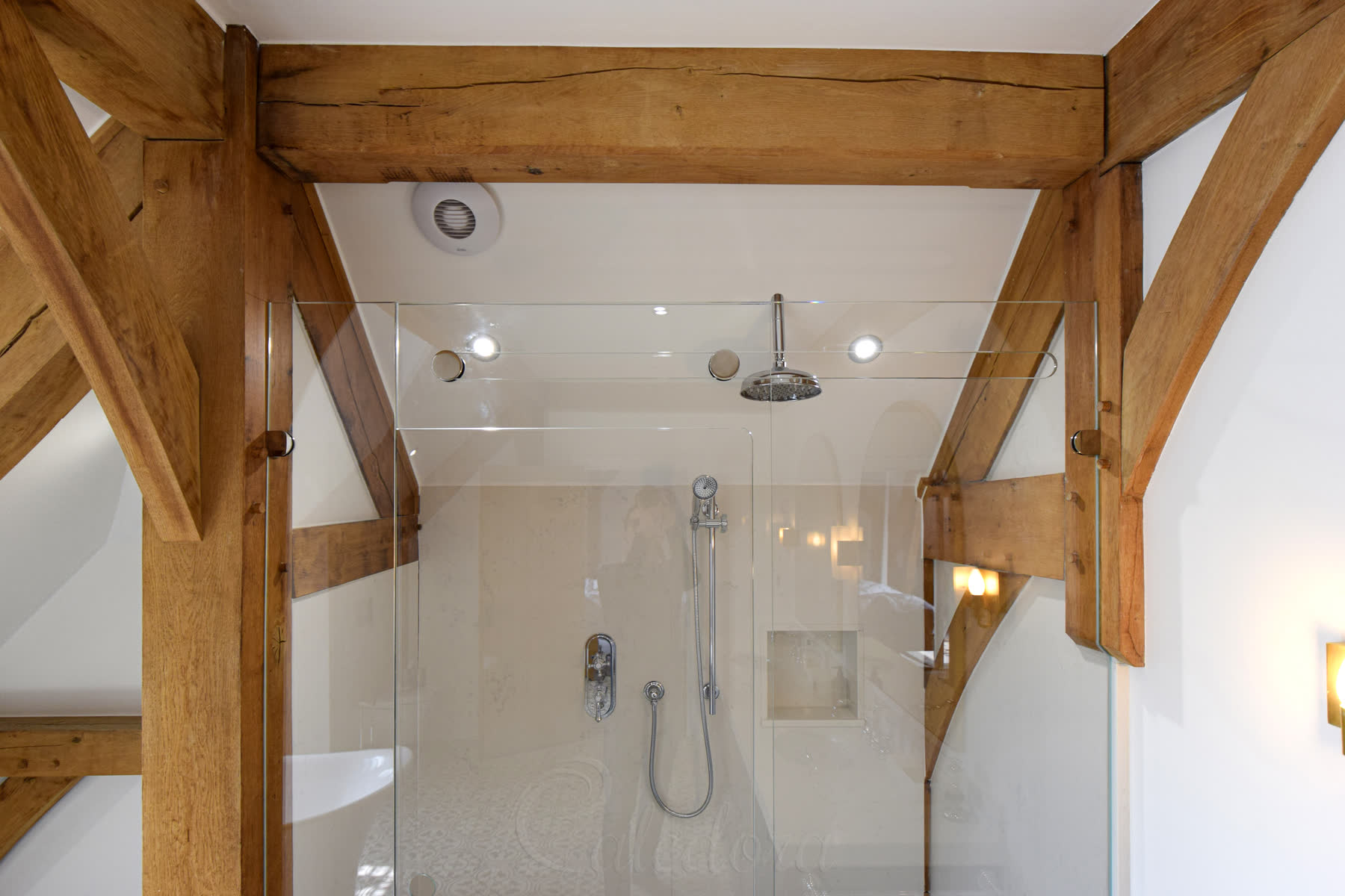 Complete trackless sliding shower installation showing natural stone walls and timber beam integration