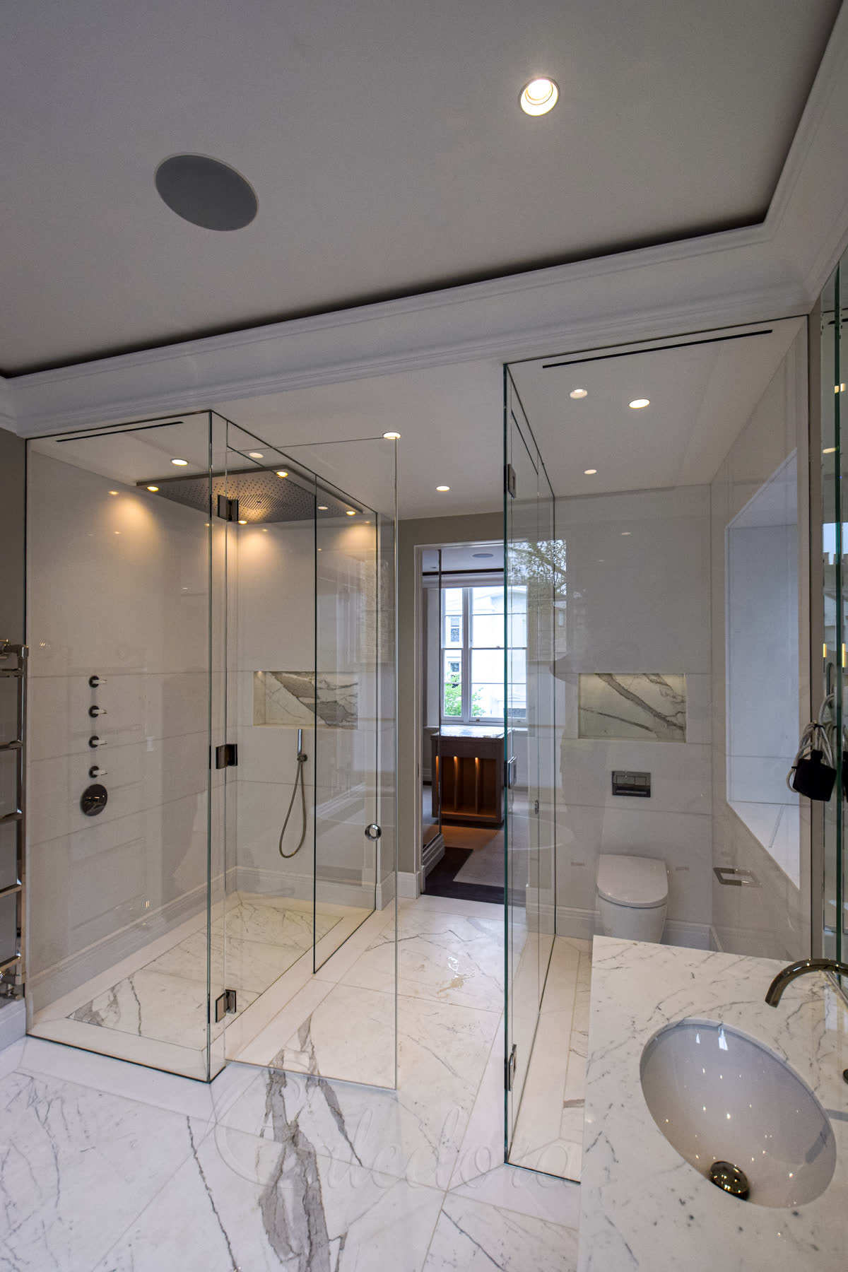Corner positioned walk-in frameless shower enclosure with door on long side in London luxury bathroom