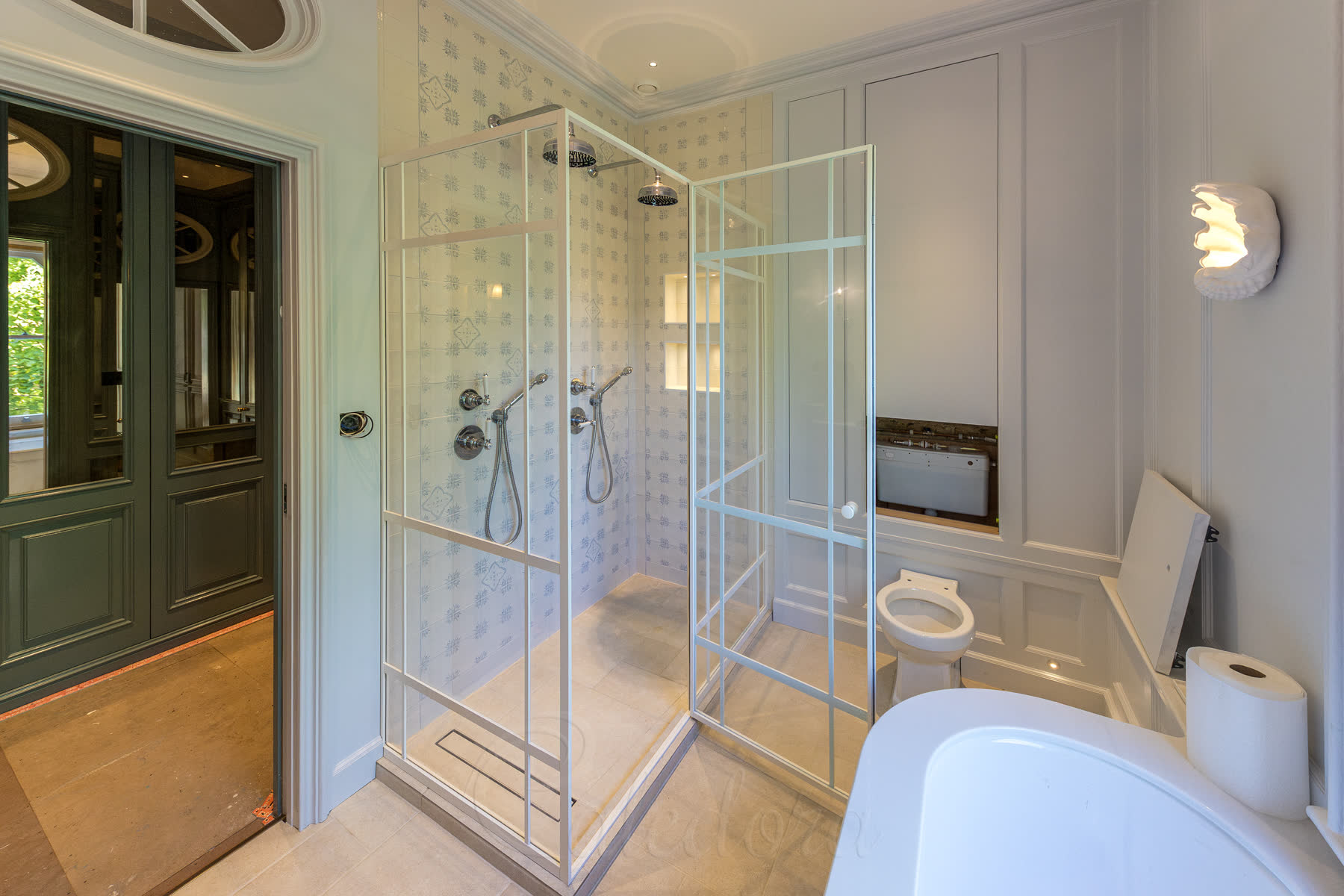 Wide bathroom view showing completed white shower enclosure installation