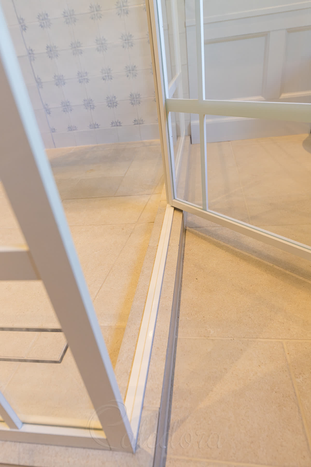 White threshold and bottom door seal detail in shower enclosure