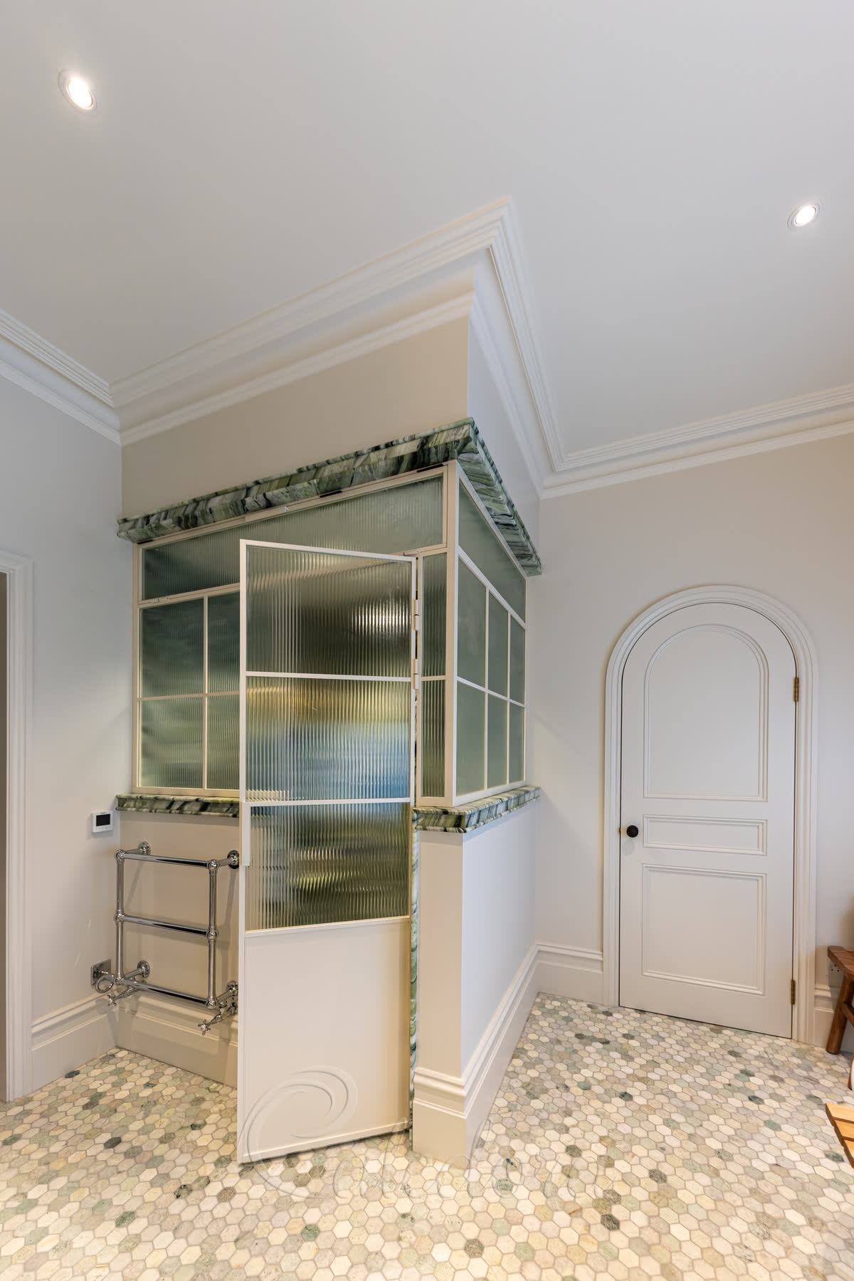 Steam shower door with white grid frame partially opened showing the interior marble surfaces