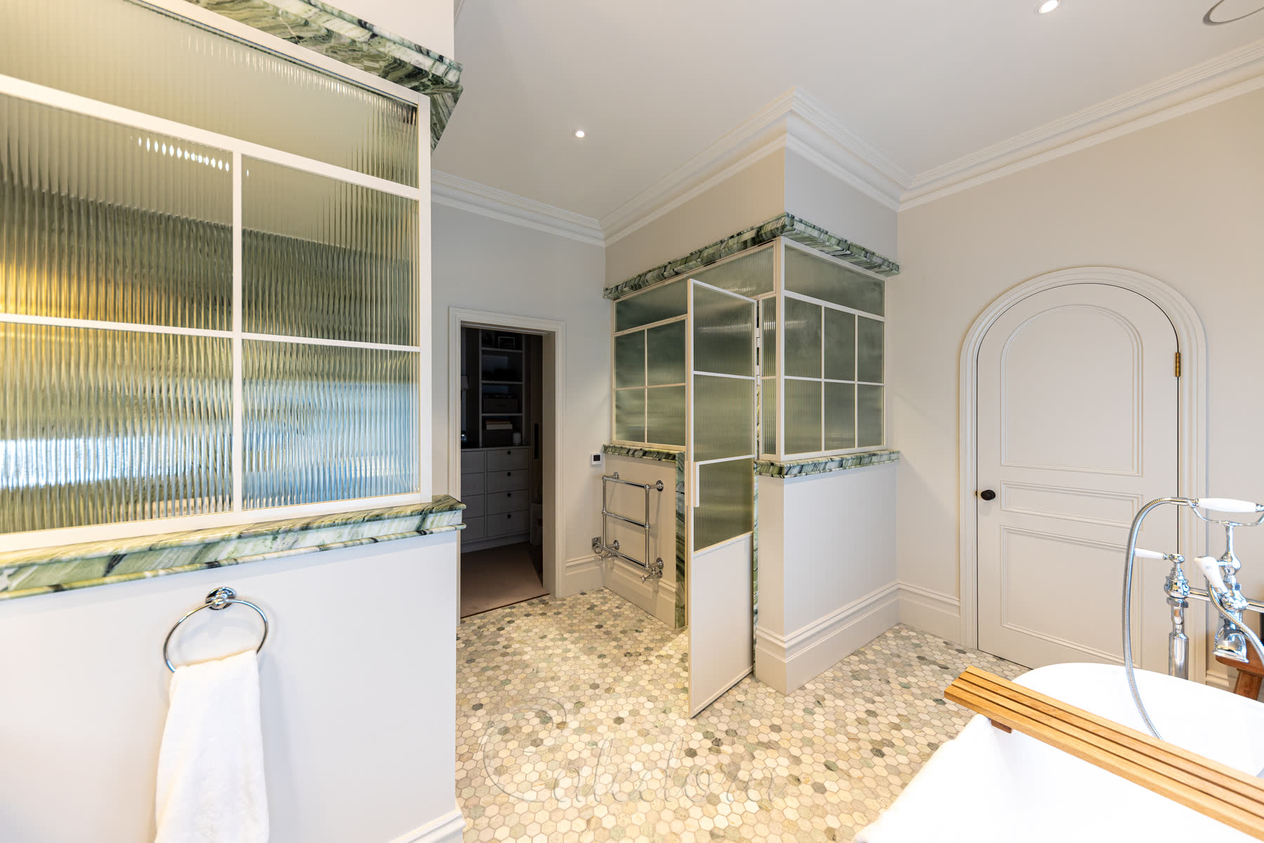 Side view of the bathroom showing both enclosures with closed doors and complementary towel rails mounted nearby