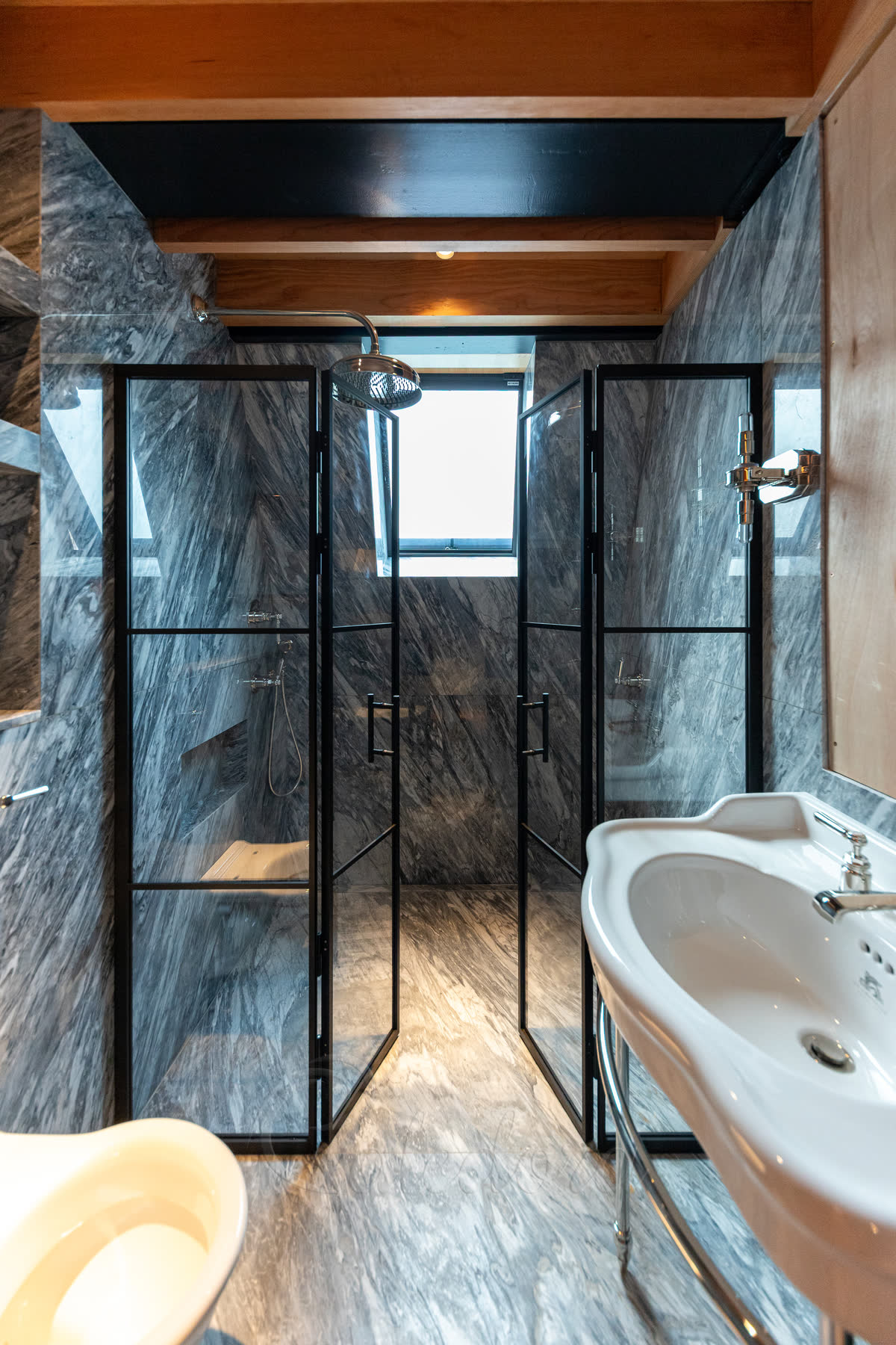 Satin black grid framed double shower doors (30mm outer, 14mm middle bars) partially open inward with magnetic closure between leaves, no threshold and a ladder handle detail