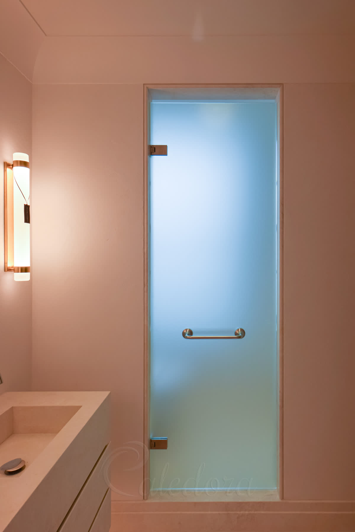 Frosted glass shower door with 10mm acid-etched glass and brushed stainless hardware mounted on natural stone, texture faces outward, dual towel rails through the glass