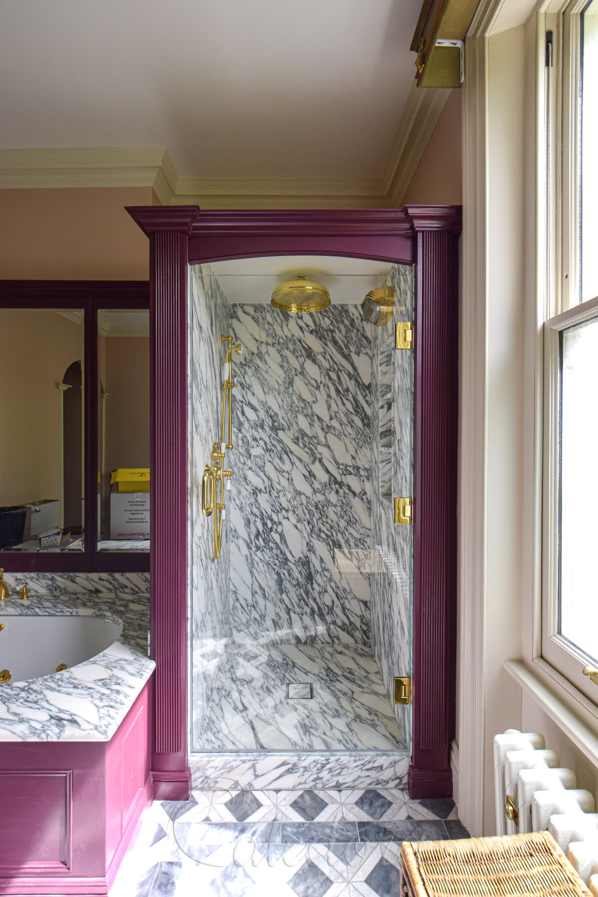 Wide polished brass swing shower door (850mm) with three polished brass hinges, 10mm ultra clear toughened glass and a 200mm pull handle, mounted on a marble shower with timber frame