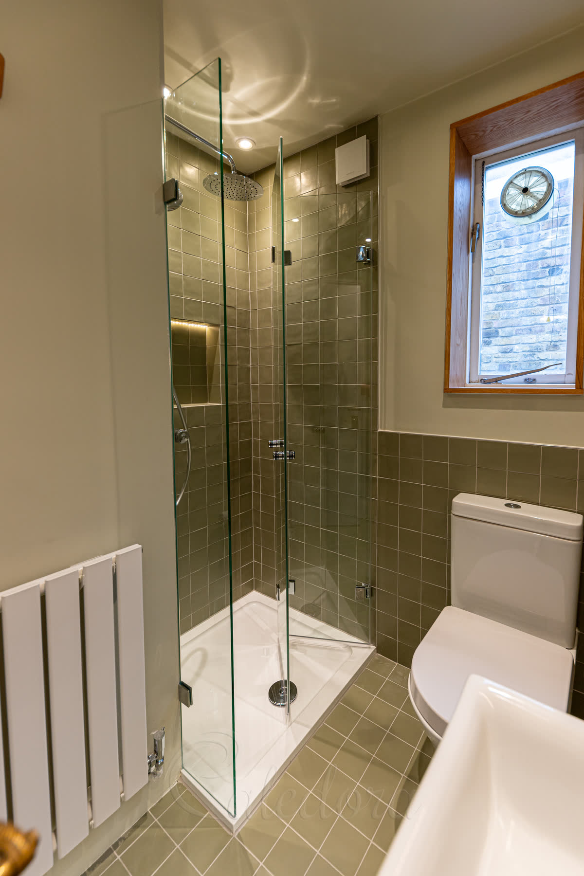 Bifold shower door frameless with chrome hinges in compact bathroom