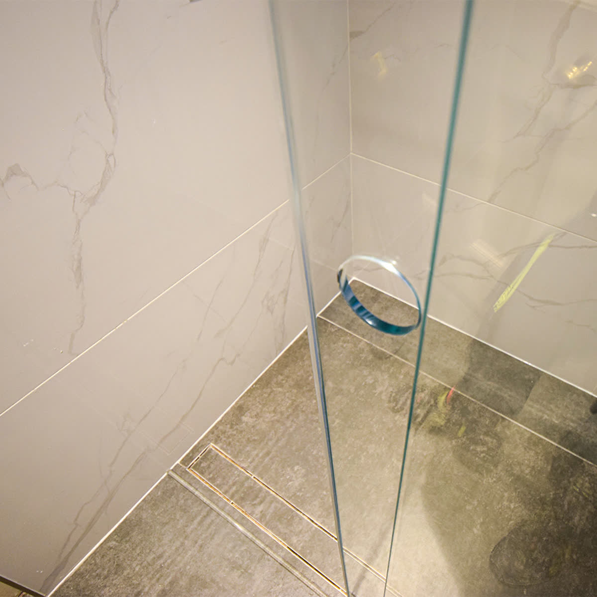 Circular polished hole cut through the sliding glass door as a frameless handle