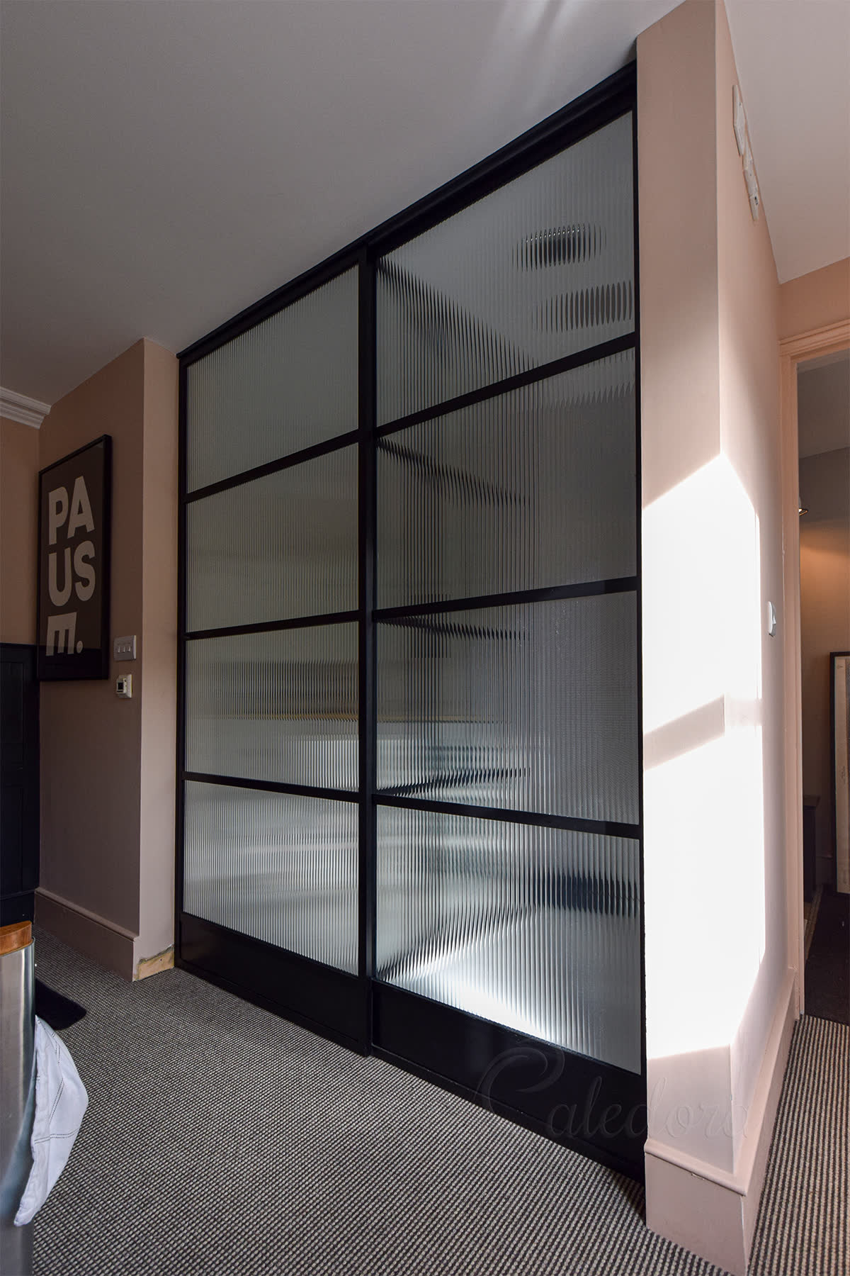 Custom framed sliding shower door with aluminium frame, designed to carry textured or laminated glass without the line-marking a frameless floor guide would cause