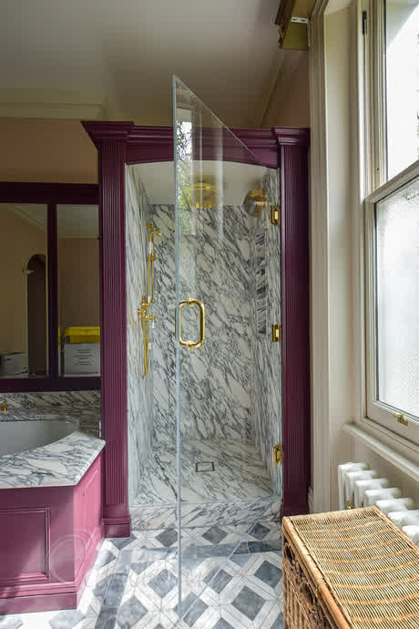 shower door with brass hinges surrounded by a custom timber frame