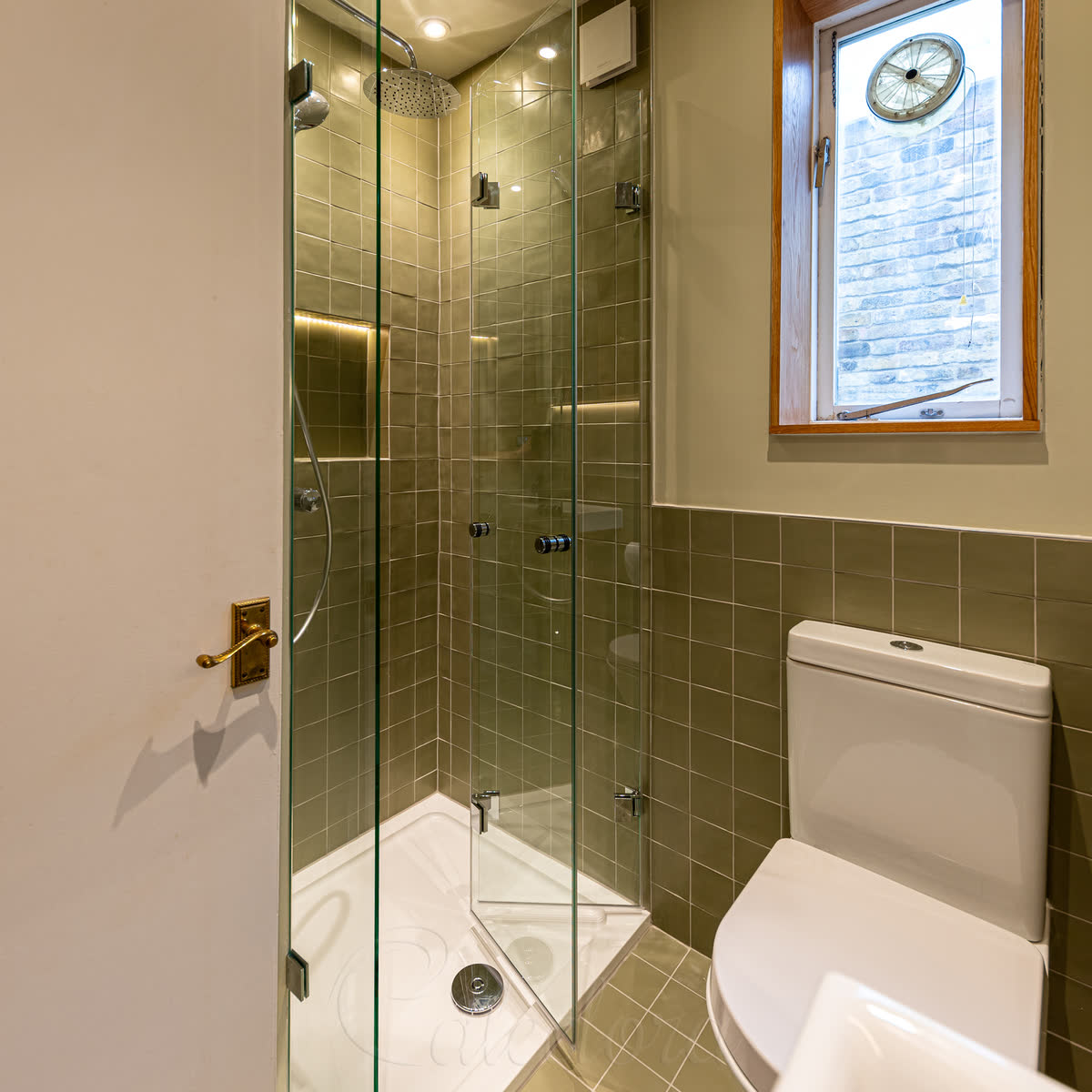 Compact bifold shower enclosure in corner alcove, space-saving design for small bathrooms