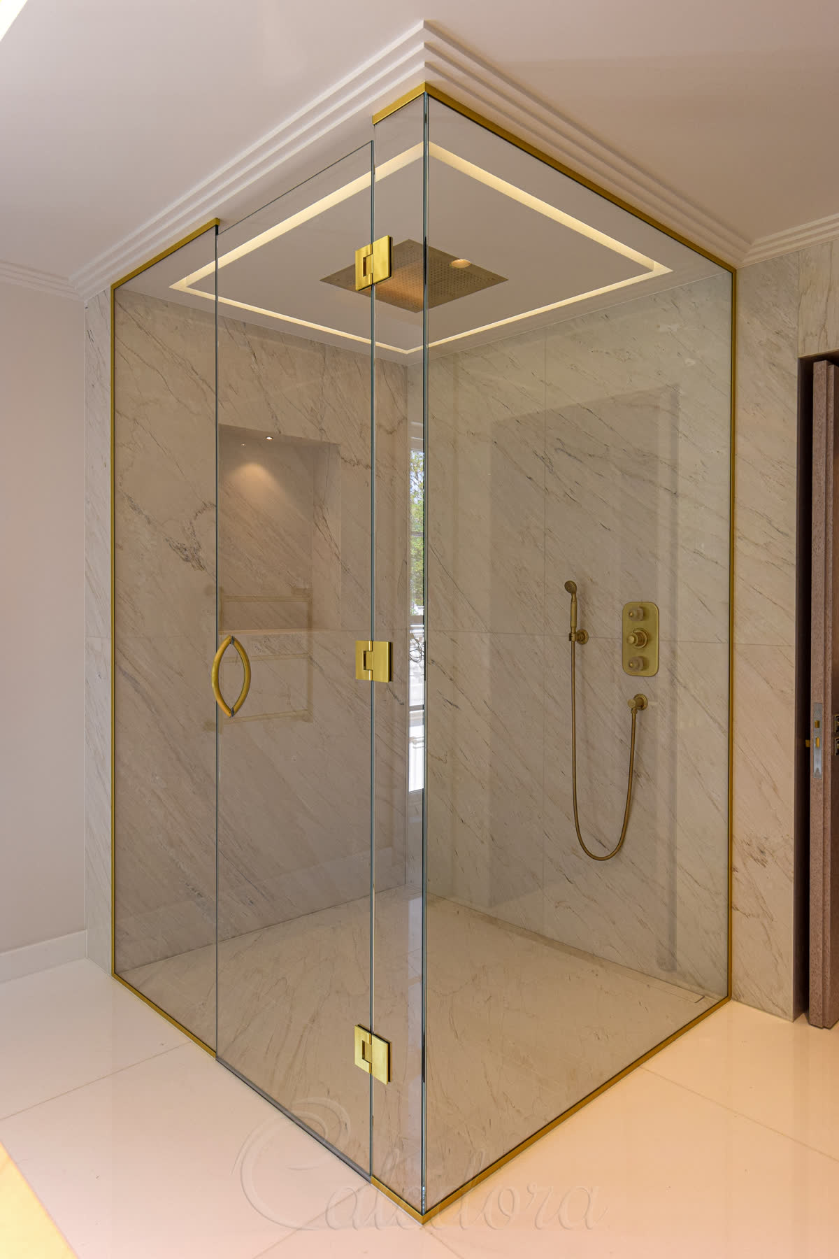 Frameless corner shower enclosure with brushed brass hinges and wall-recessed panels in period bathroom