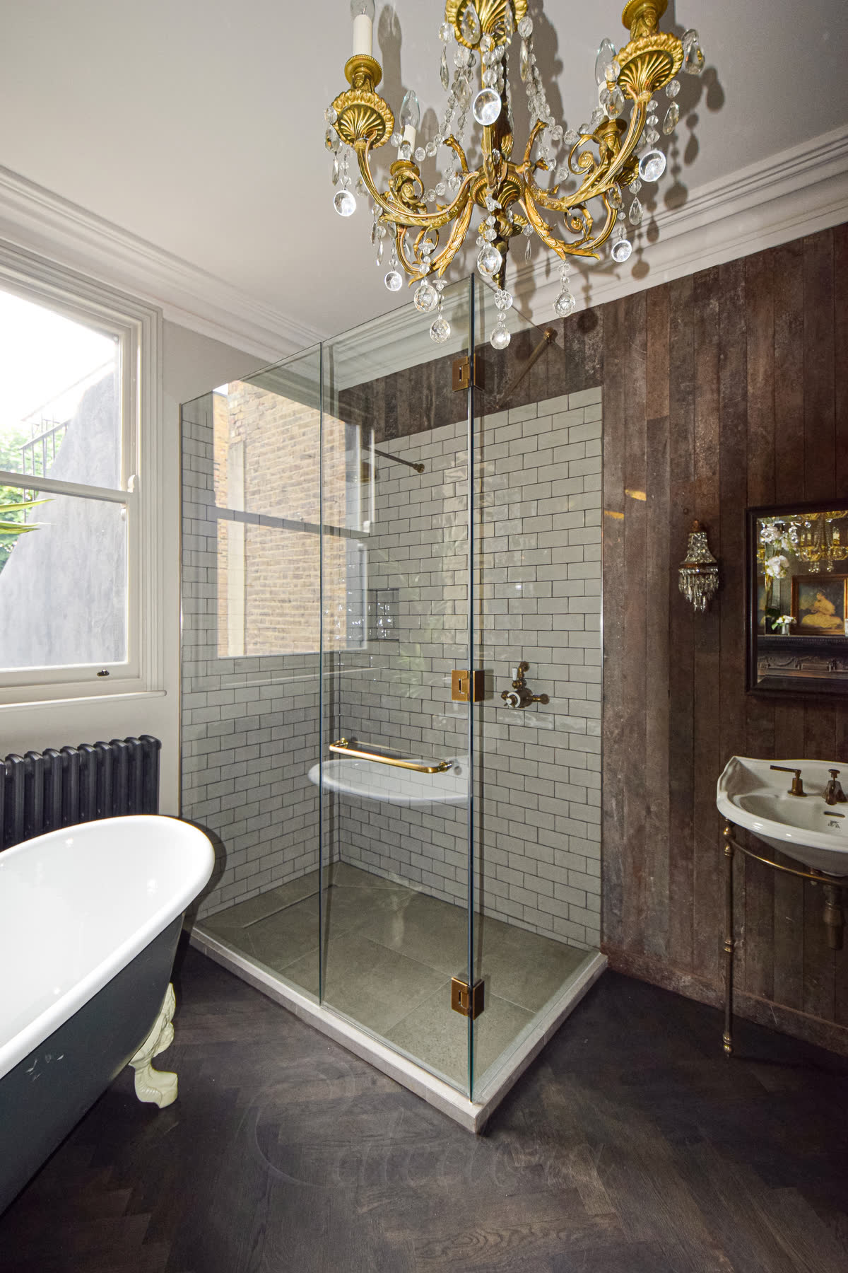 Frameless glass shower enclosure with antique brass hinges and towel rail