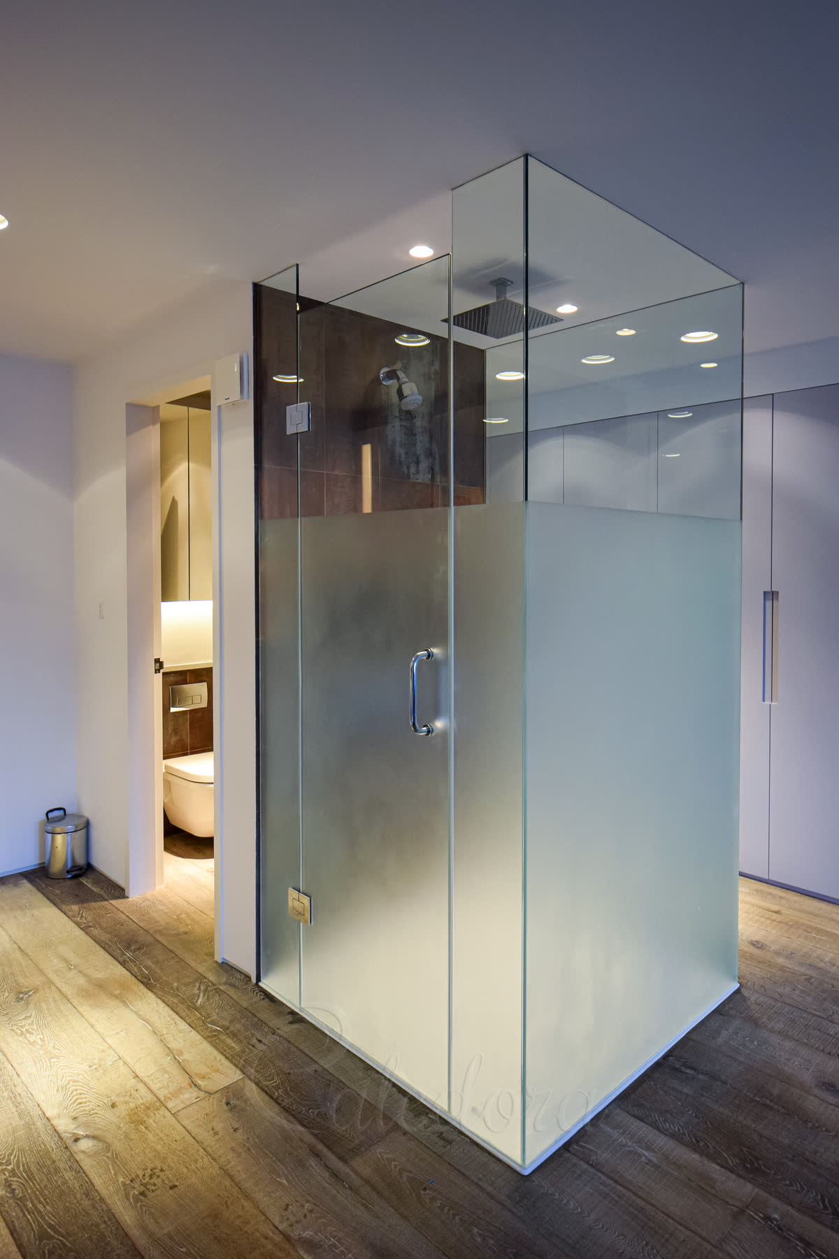 Three-sided shower enclosure with frosted privacy glass and chrome fixtures