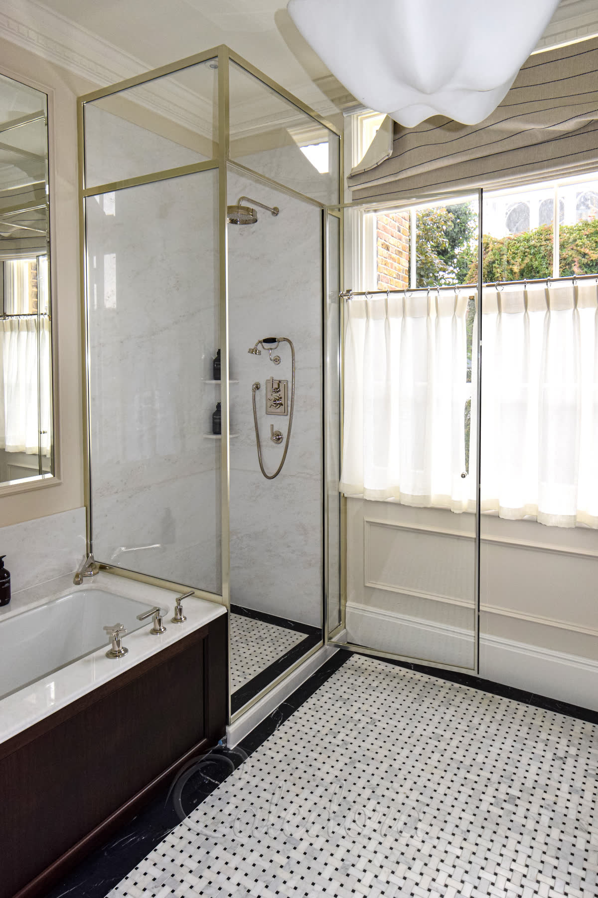 Tall square shower enclosure with nickel frame over bath