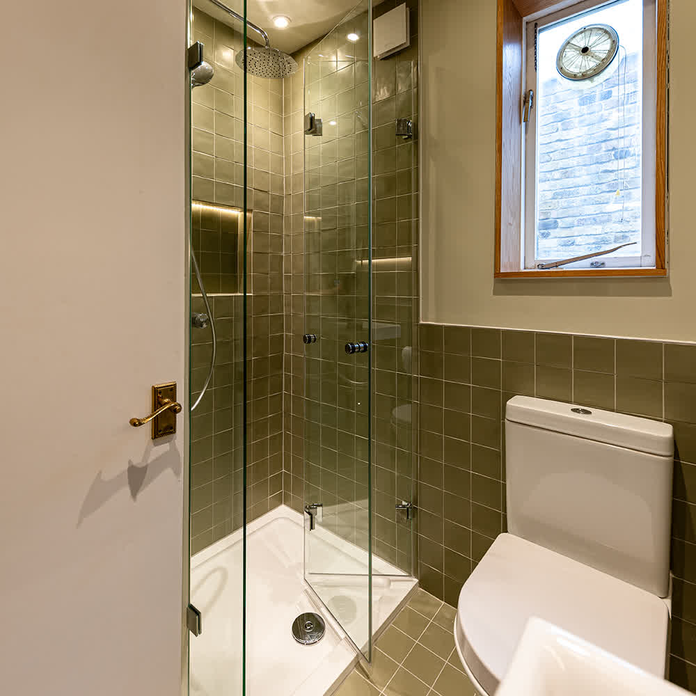 Bifold shower door in a shower enclosure with chrome hinges