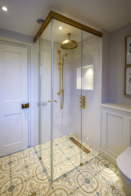 sliding shower enclosure with a brass track