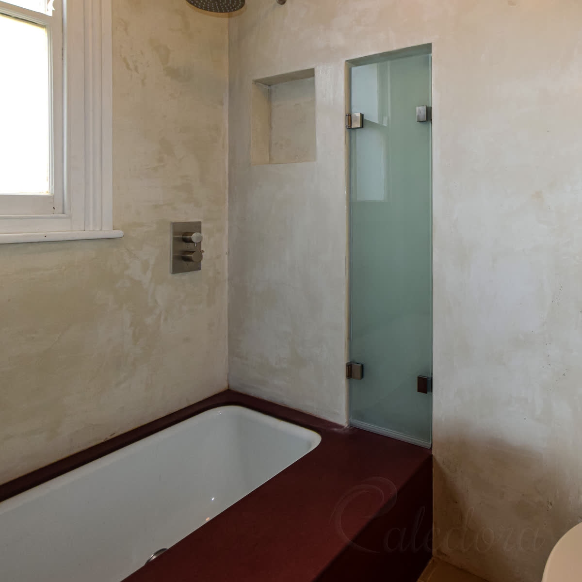 Two frosted folding bath screen panels folded away into a recess in the wall beside the bath, leaving the whole bath open
