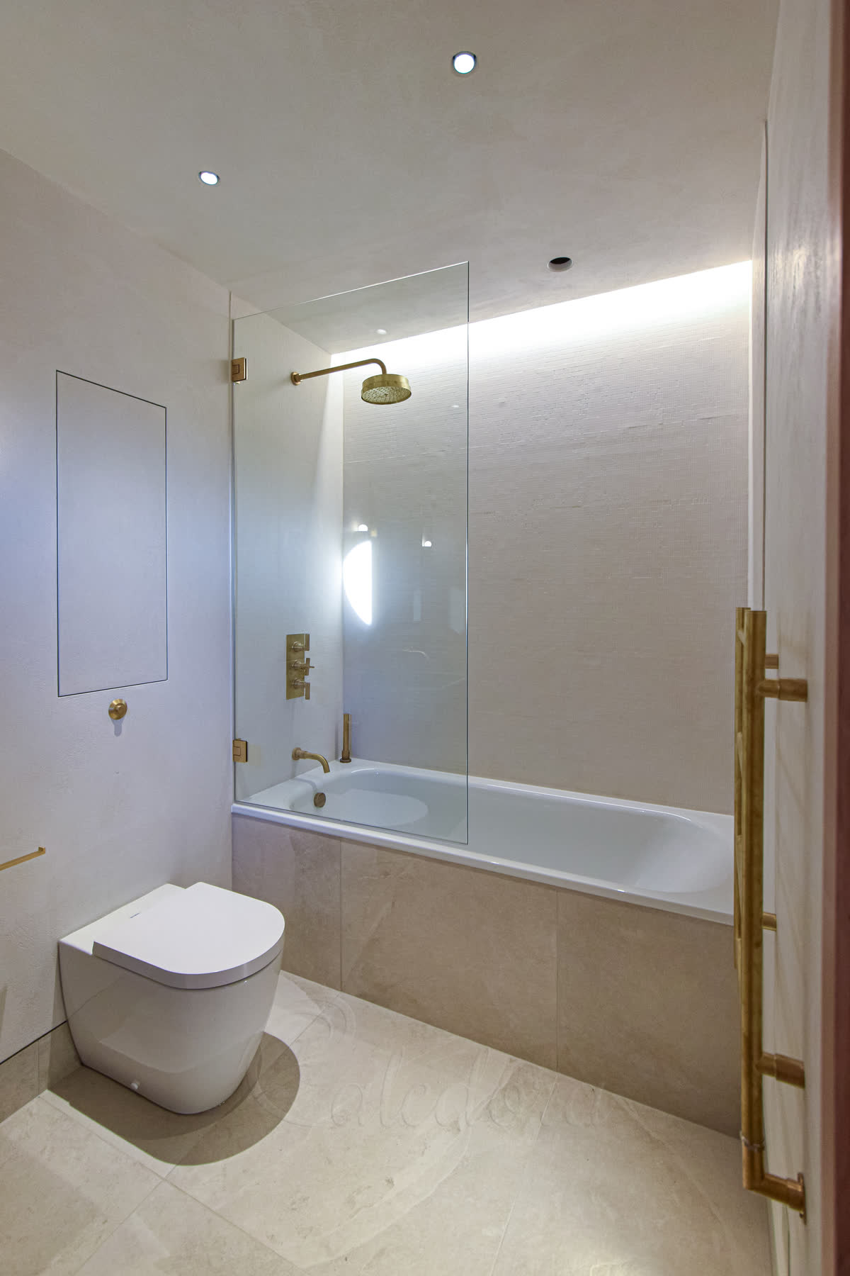 Brushed brass bath screen in closed position over a London bath