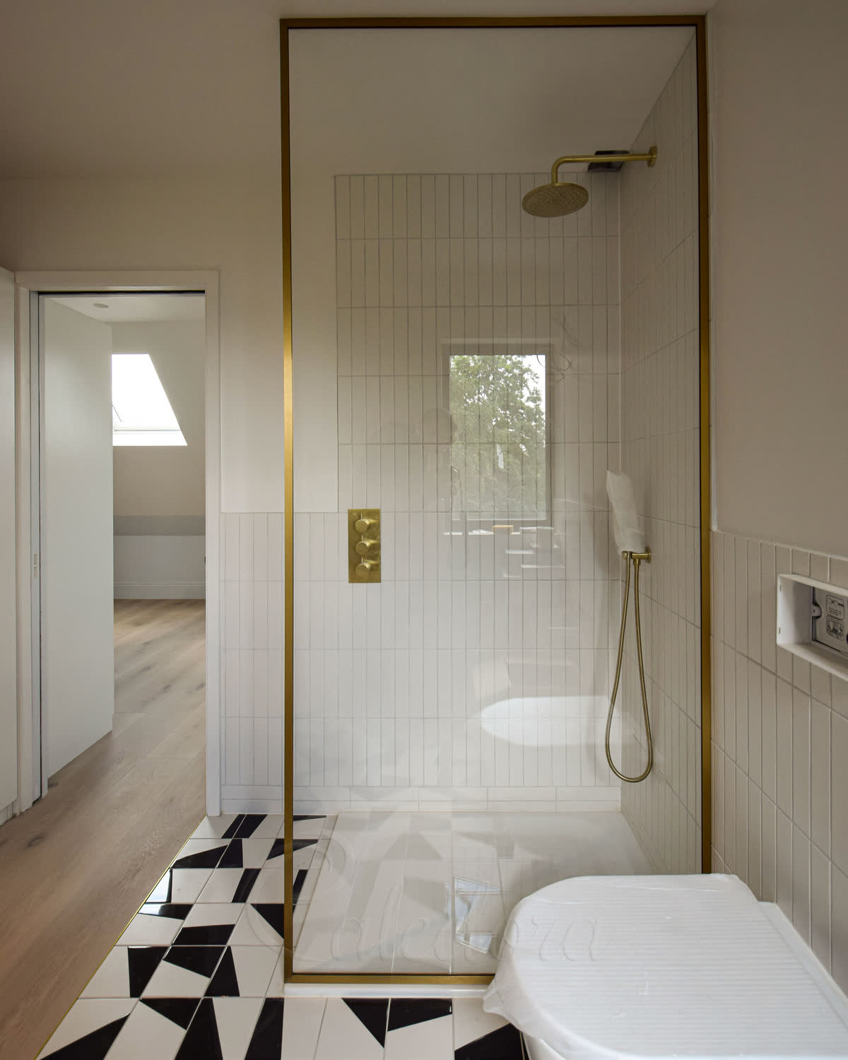 Full-height brushed brass shower screen with Ultra Clear glass in a London bathroom
