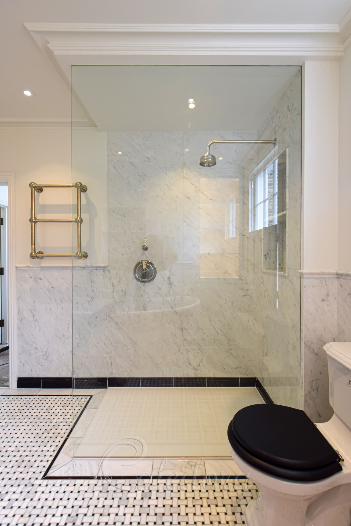Frameless full-height shower screen with no visible metal frame, single panel of toughened glass in a London bathroom