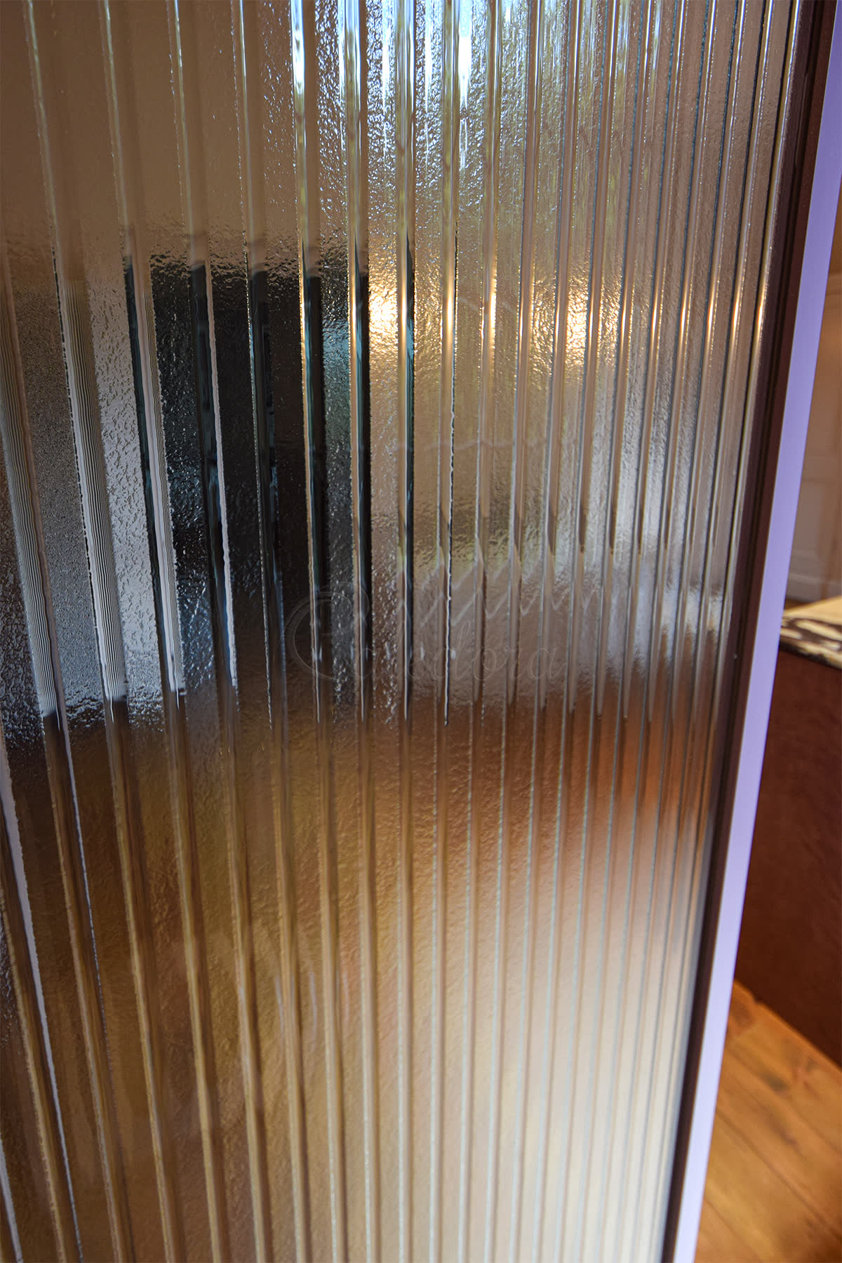 Kiln-formed shower screen with bespoke vertical-ribbed texture melted into the glass surface