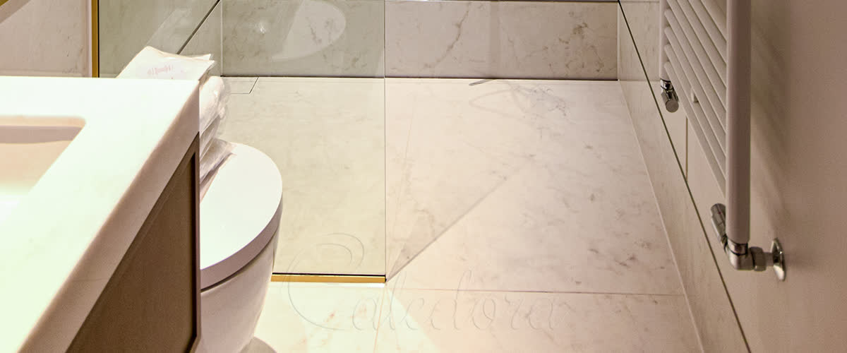 Short shower screen with brass fixtures and marble tiles in a Cookham bathroom